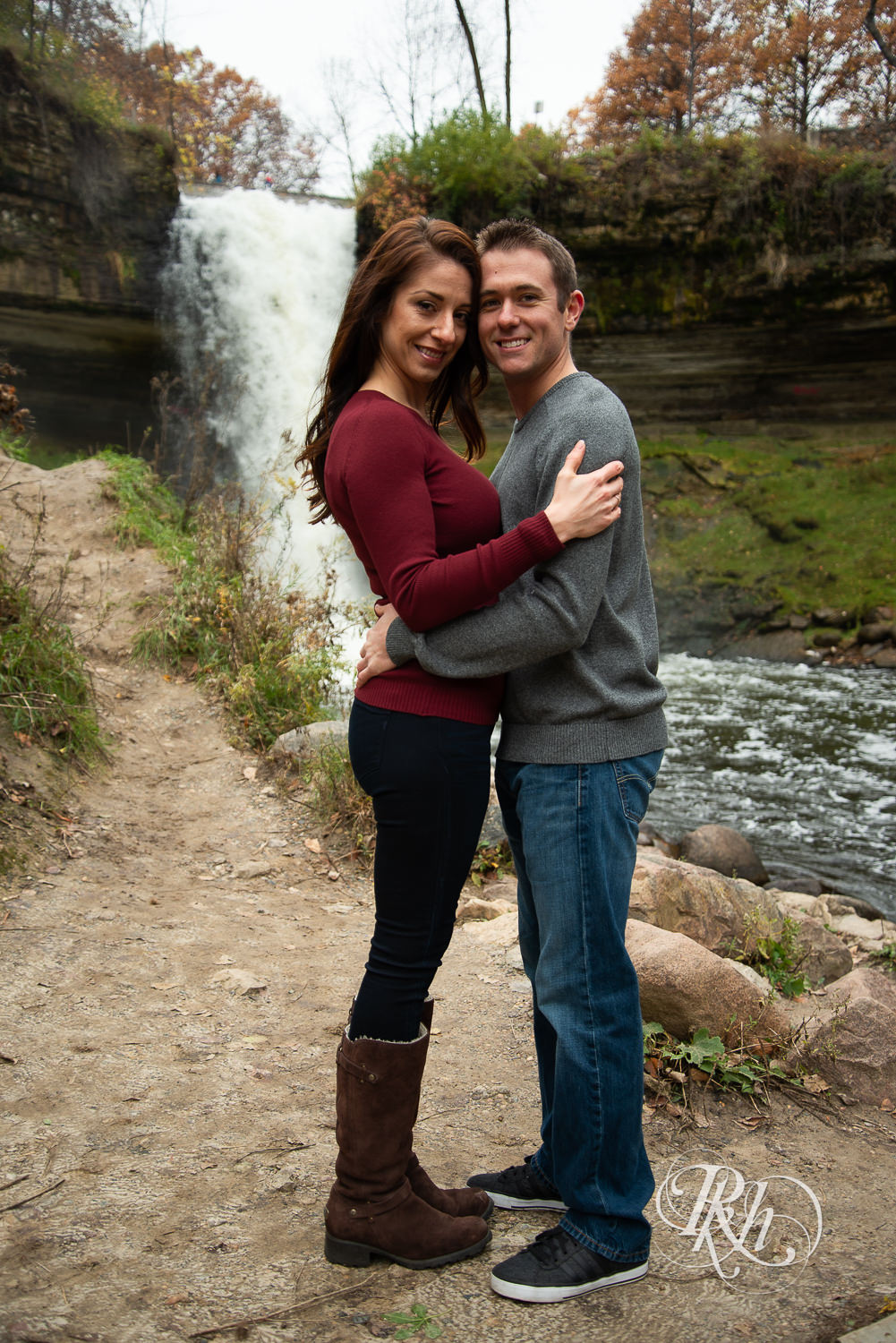 Man and woman smile in front of Minnehaha Falls in Minneapolis, Minnesota.