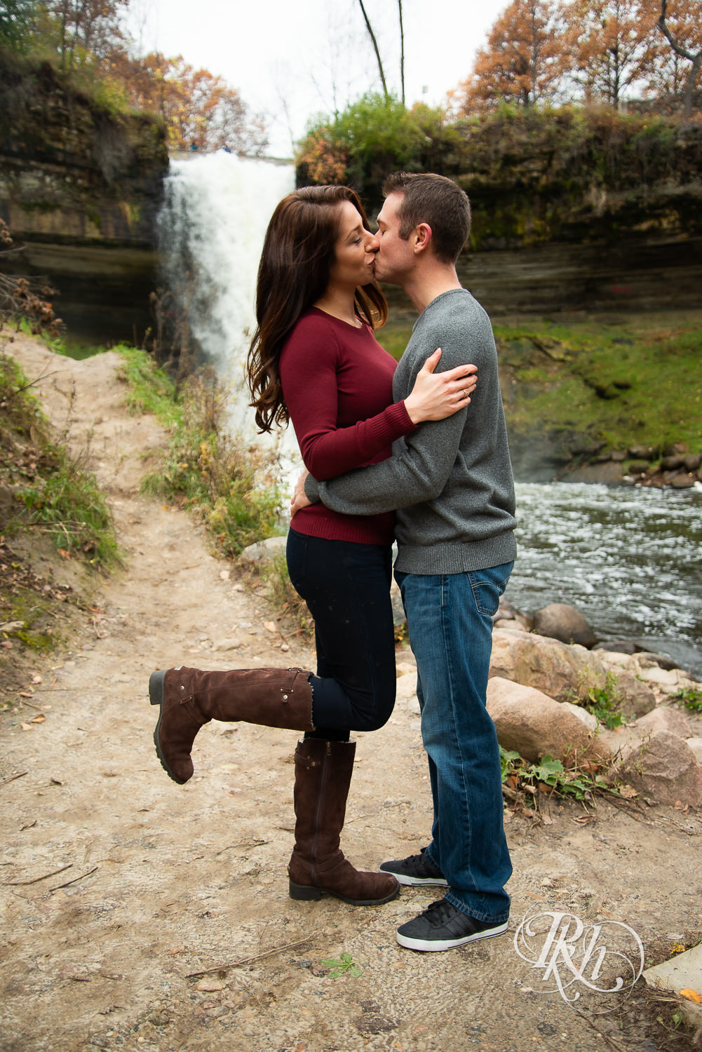 Man and woman kiss in front of Minnehaha Falls in Minneapolis, Minnesota.
