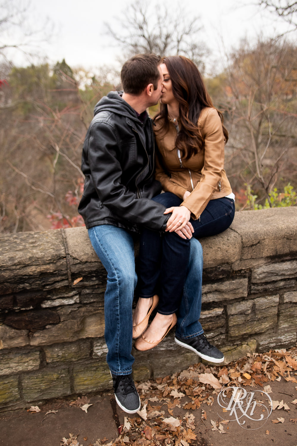 Man and woman kiss during Minnehaha Falls engagement photos in Minneapolis, Minnesota.