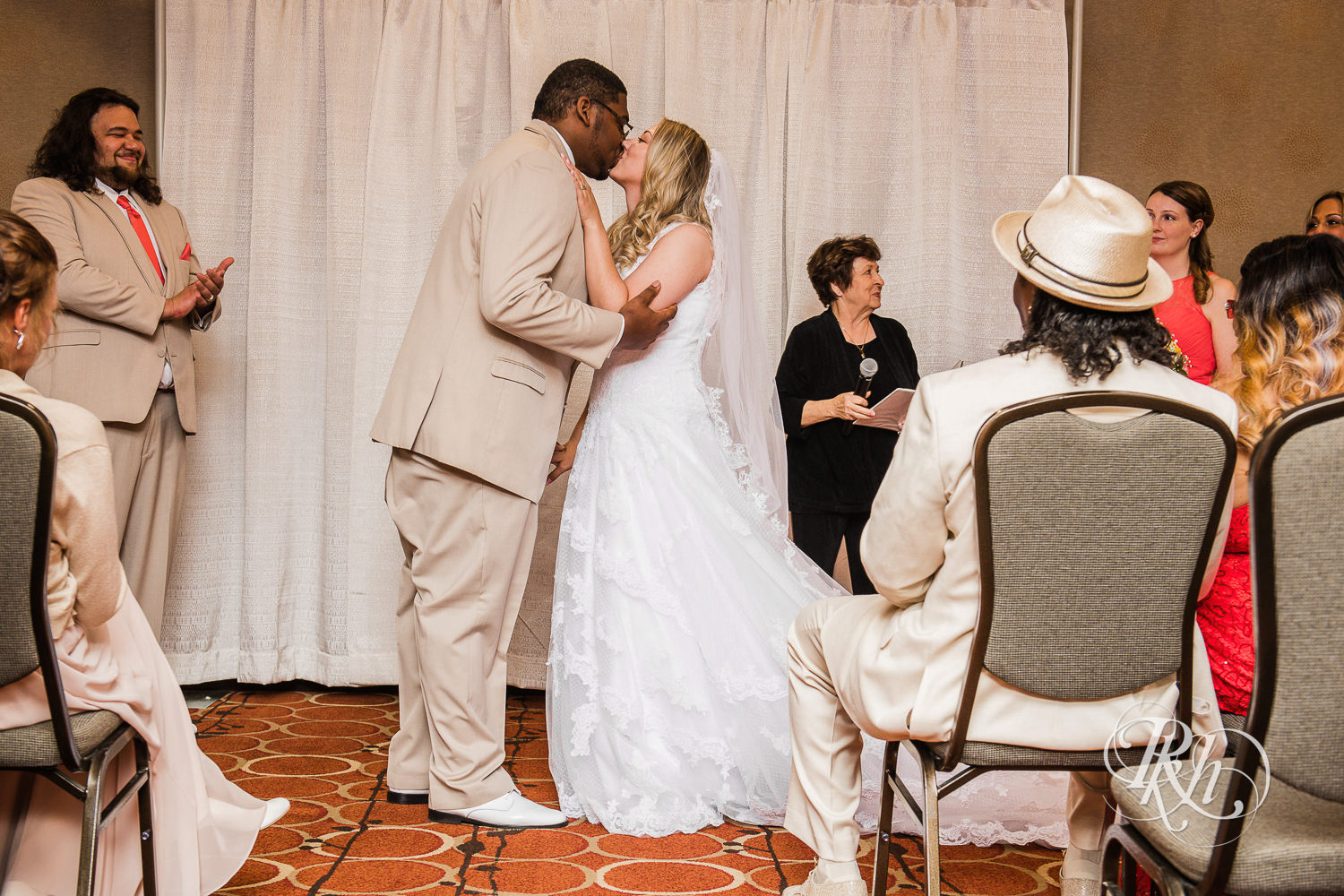 White bride and black groom kiss during wedding ceremony at North Metro Event Center in Shoreview, Minnesota.