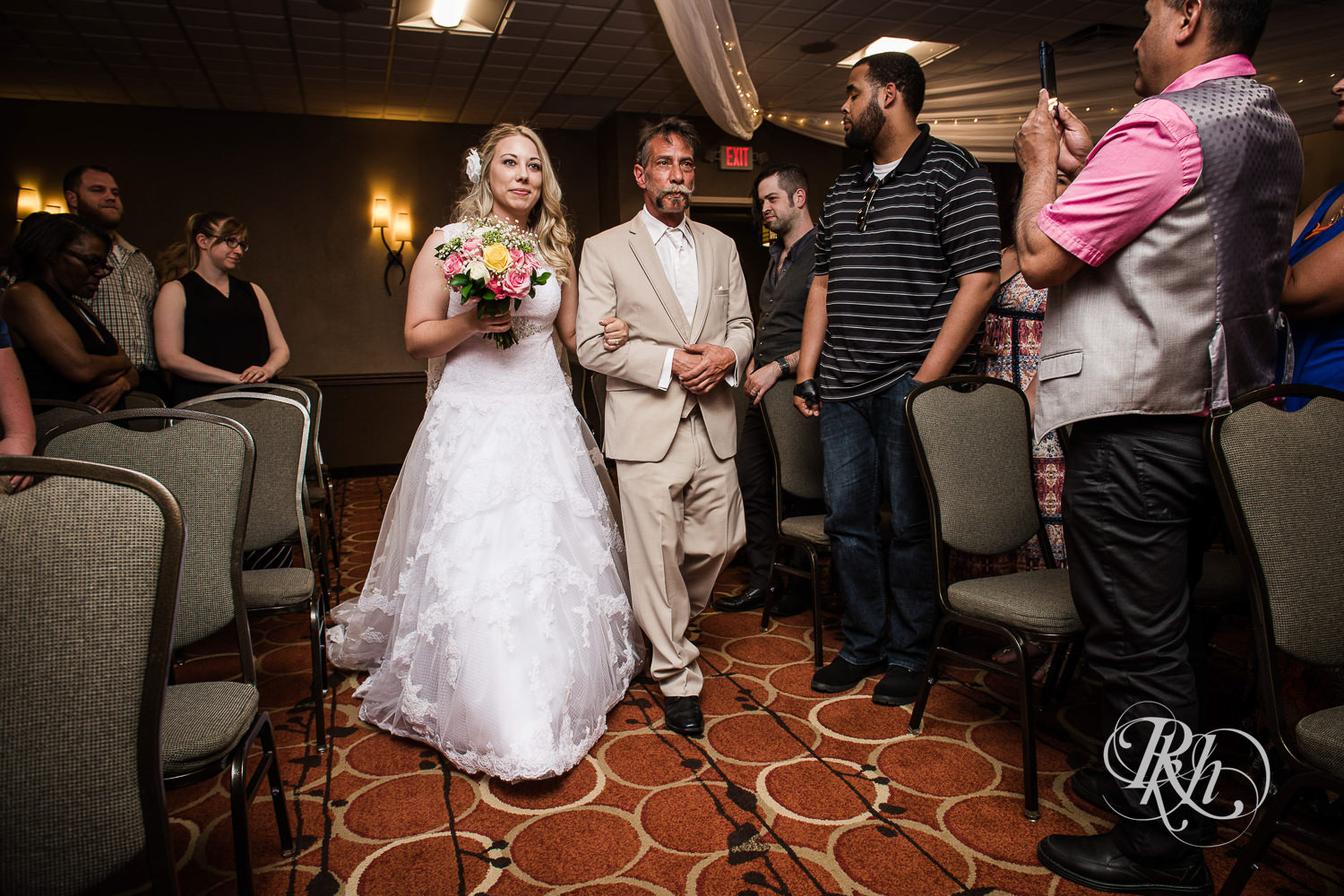Bride walks down the aisle during wedding ceremony at North Metro Event Center in Shoreview, Minnesota.