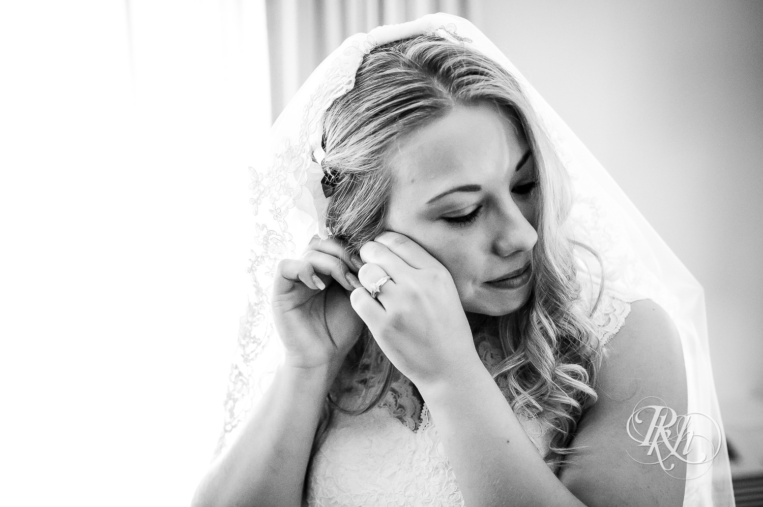 Bride putting on earrings before the wedding at North Metro Event Center in Shoreview, Minnesota.