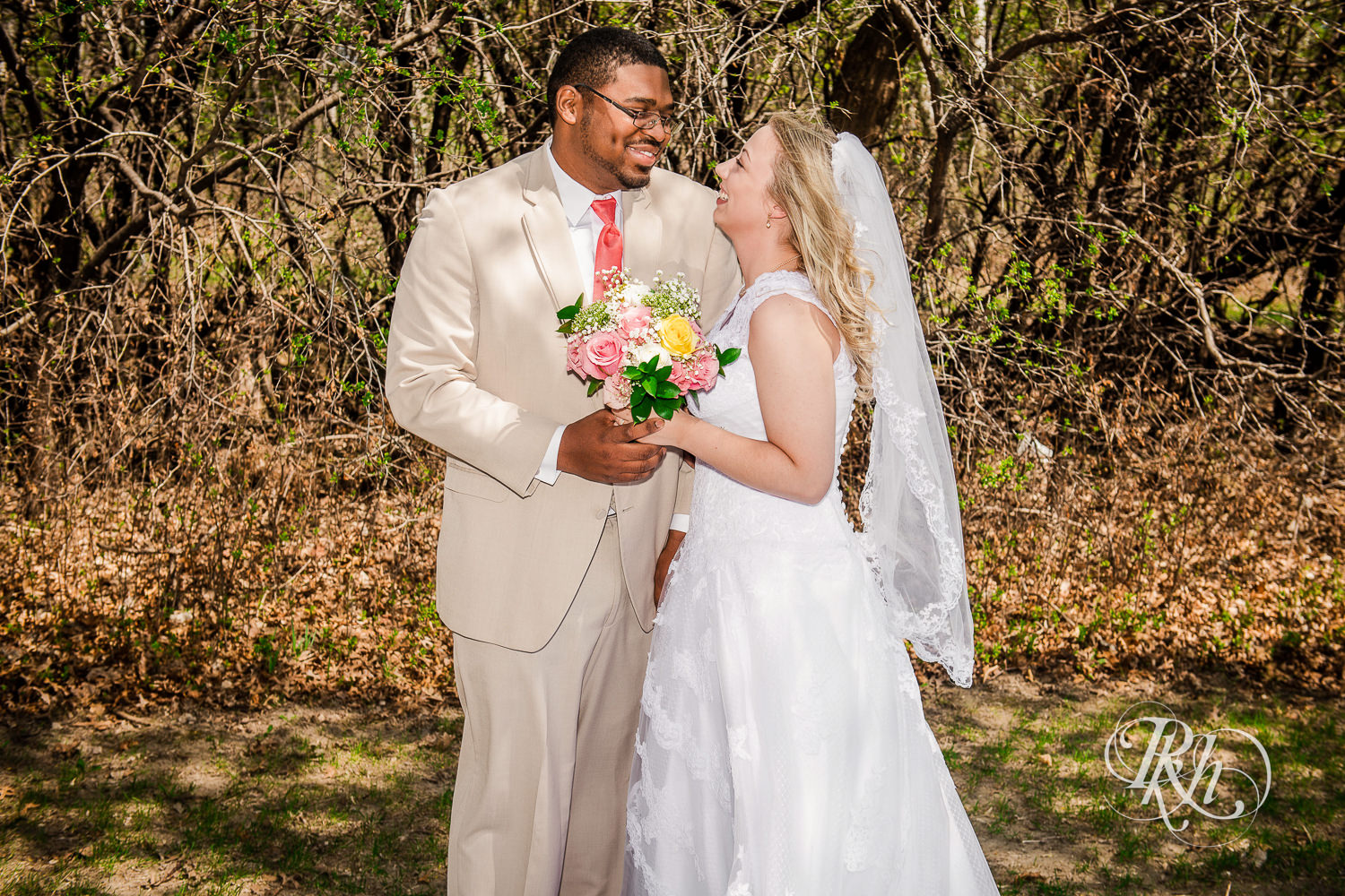 White bride and black groom smile during at North Metro Event Center wedding in Shoreview, Minnesota.