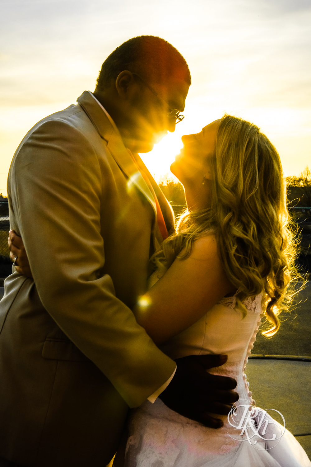 Bride and groom kiss at sunset at North Metro Event Center in Shoreview, Minnesota.