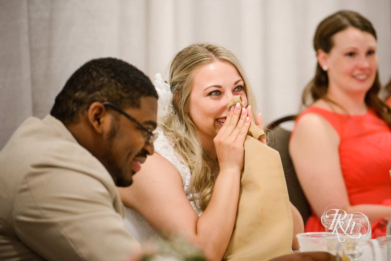 White bride and black groom smile during wedding reception at North Metro Event Center in Shoreview, Minnesota.