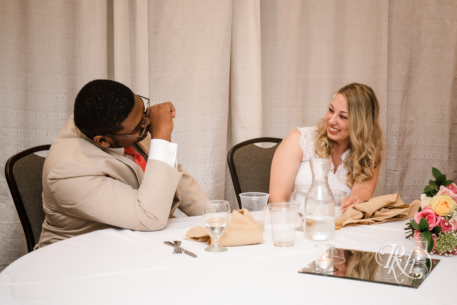White bride and black groom laugh during wedding reception at North Metro Event Center in Shoreview, Minnesota.