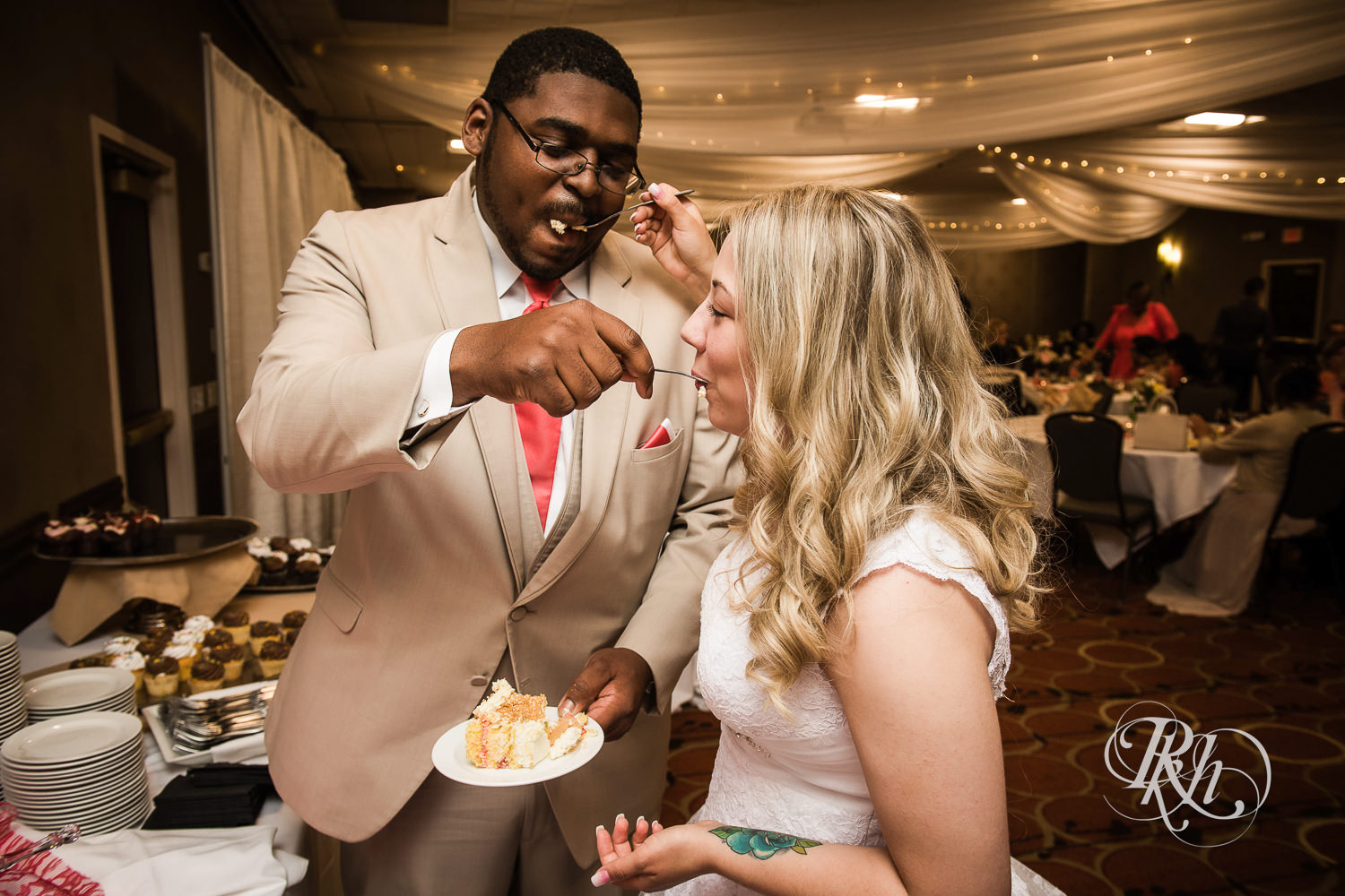 White bride and black groom cut cake during wedding reception at North Metro Event Center in Shoreview, Minnesota.