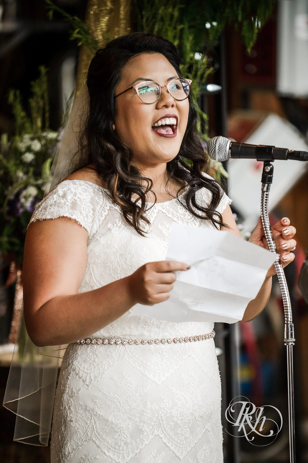 Asian bride with glasses and groom read vows during wedding ceremony at 612 Brew in Minneapolis, Minnesota.