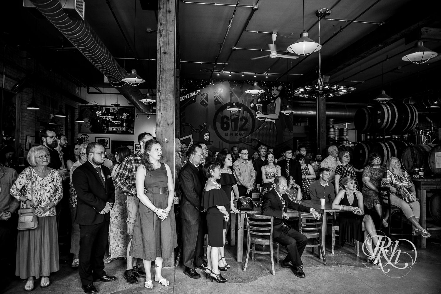 Guests look on at wedding ceremony at 612 Brew brewery wedding in Minneapolis, Minnesota.
