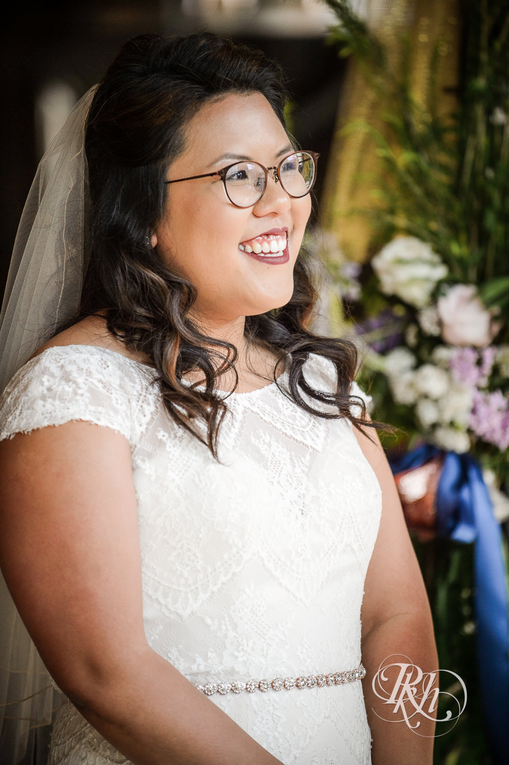 Asian bride with glasses and groom smile during wedding ceremony at 612 Brew in Minneapolis, Minnesota.