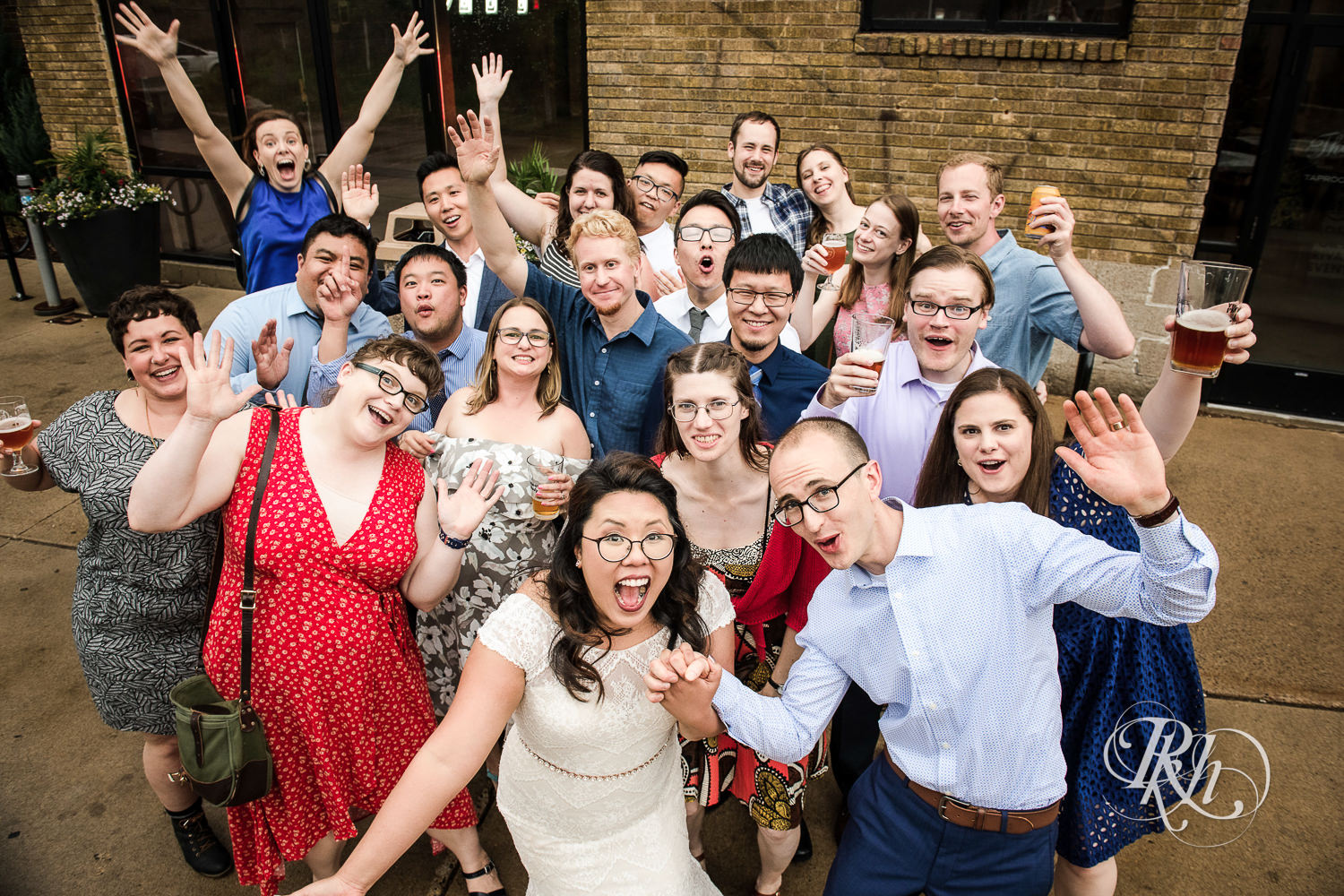 Bride and groom cheer with guests during brewery wedding reception at 612 Brew in Minneapolis, Minnesota.