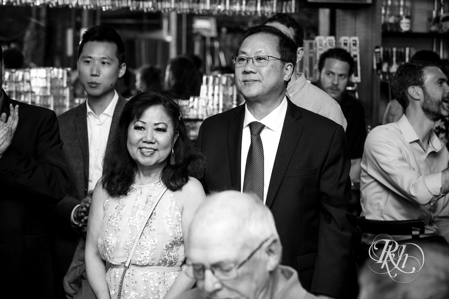 Asian parents smile during wedding speeches at 612 Brew in Minneapolis, Minnesota.