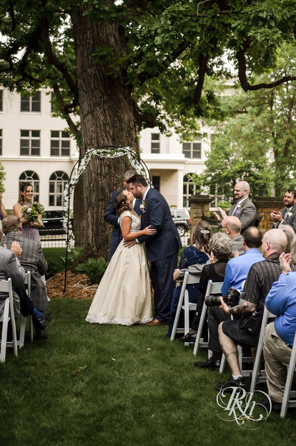 Bride and groom kiss during wedding ceremony at Summit Manor Reception House in Saint Paul, Minnesota.