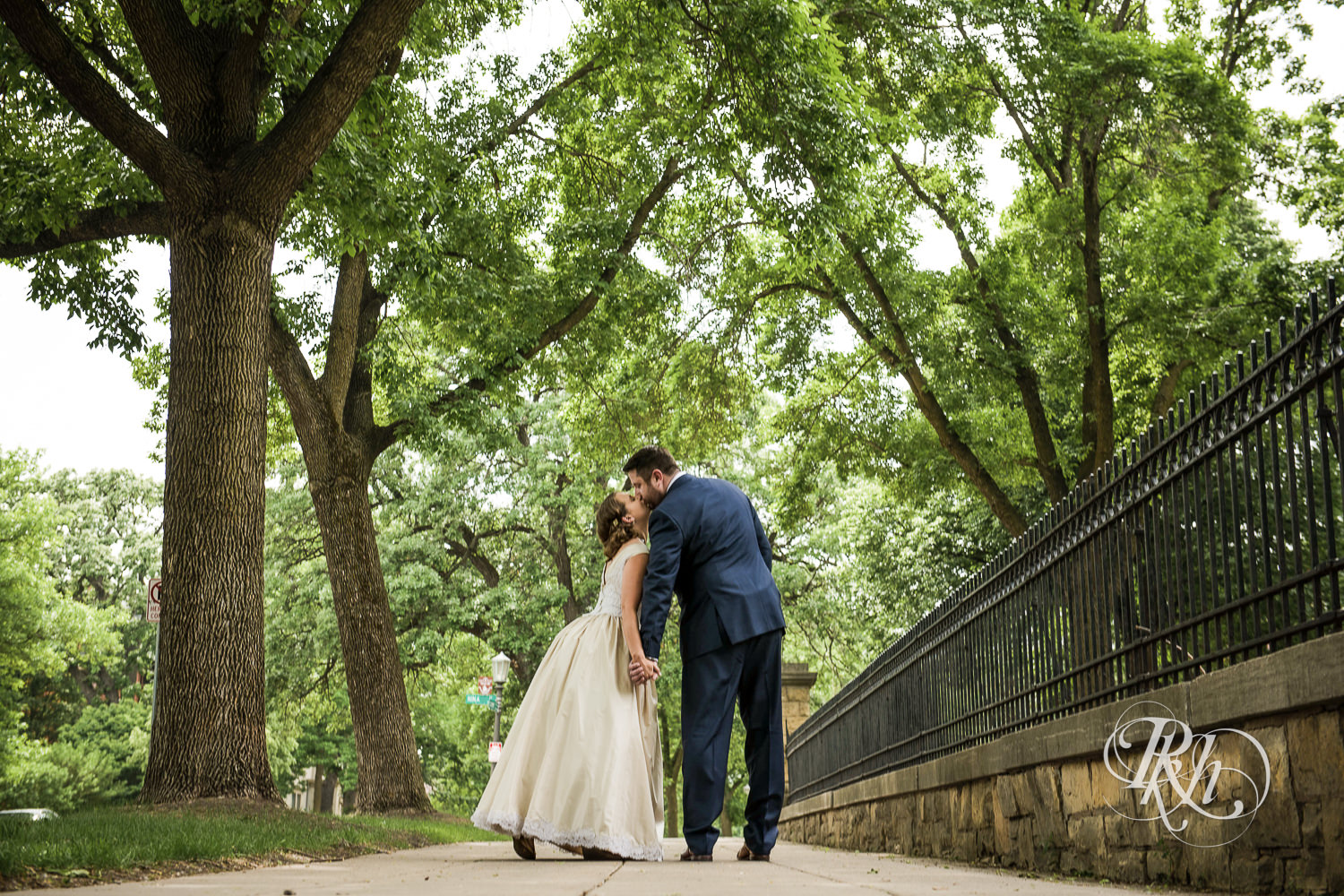 Bride and groom kiss in front of Summit Manor Reception House in Saint Paul, Minnesota.