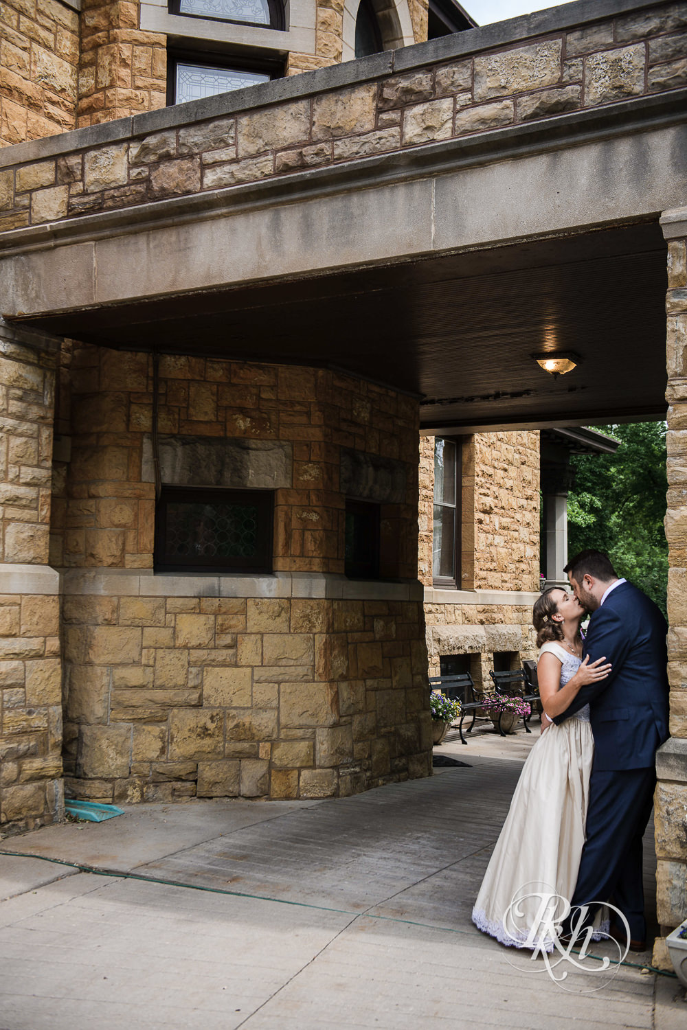 Bride and groom kiss in front of Summit Manor Reception House in Saint Paul, Minnesota.