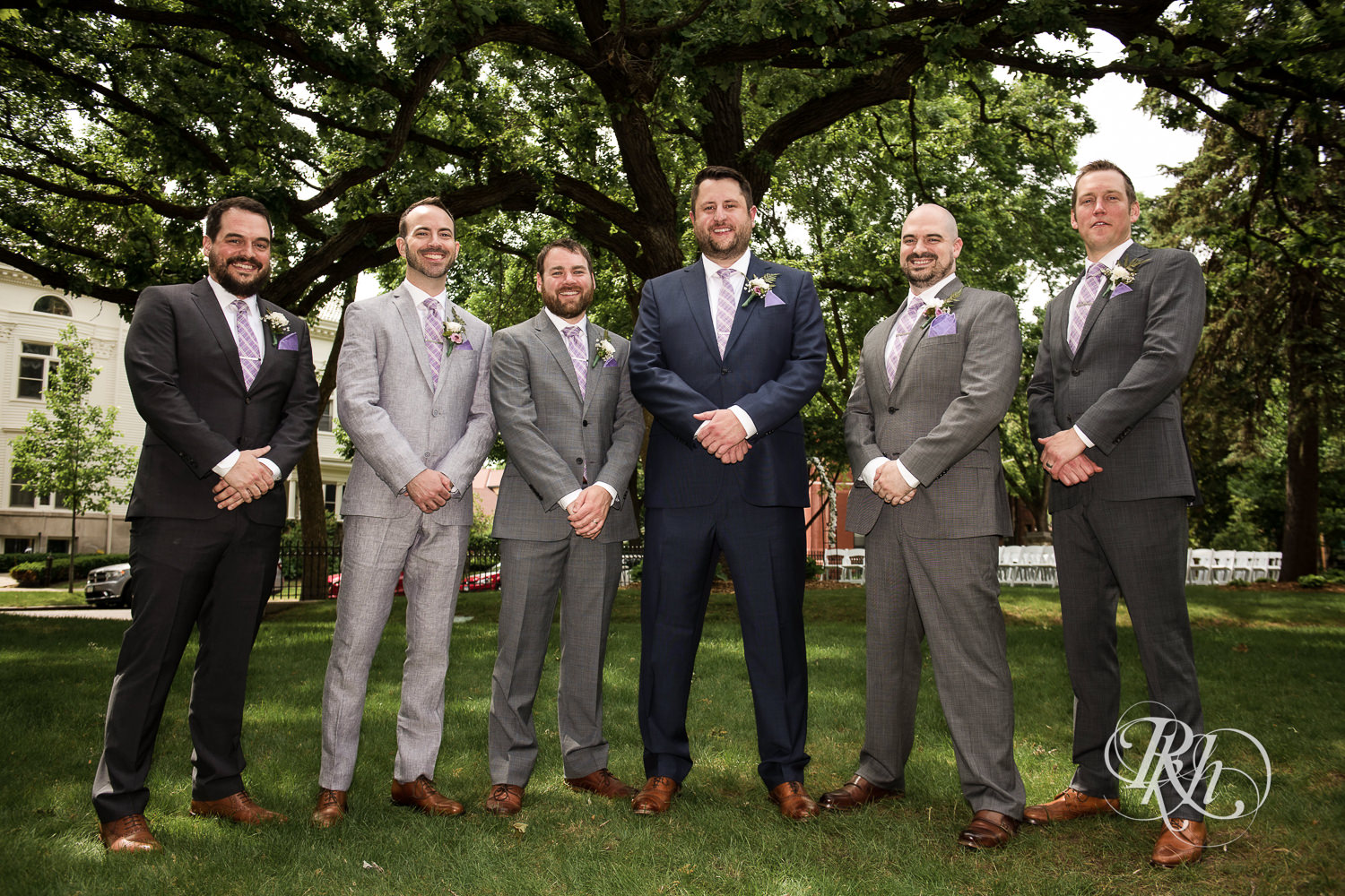 Wedding party smiles with groom at Summit Manor Reception House in Saint Paul, Minnesota.