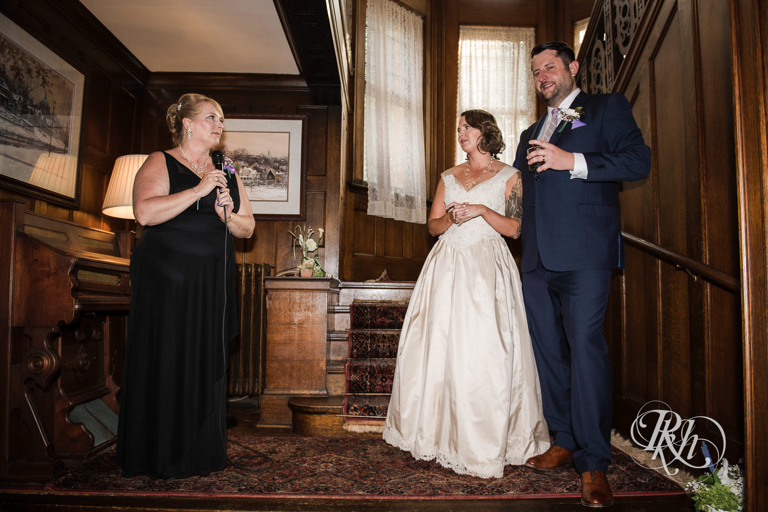 Bride and groom watch as speeches are given during wedding reception at Summit Manor wedding in Saint Paul, Minnesota.