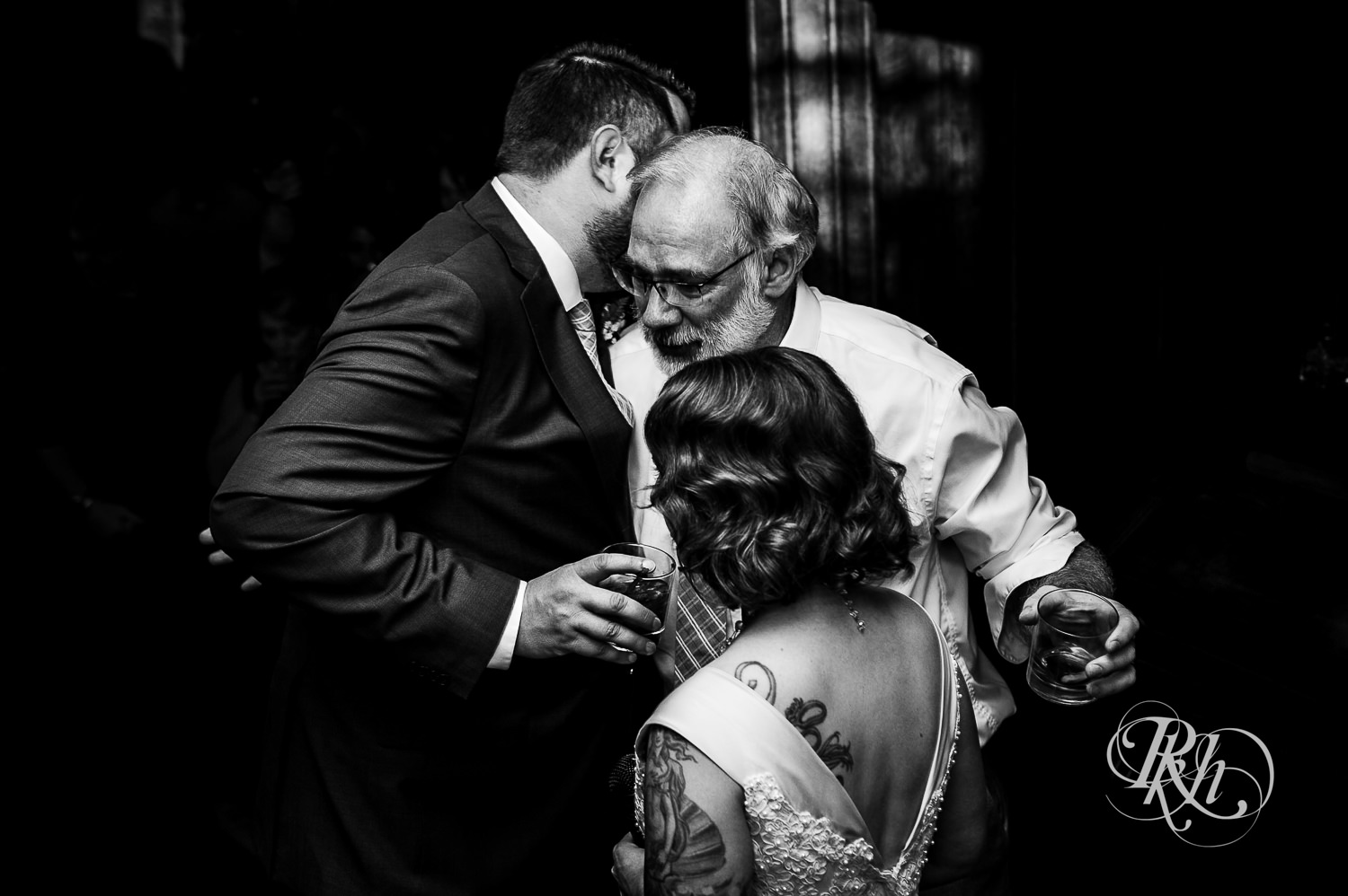 Bride and groom hug bride's dad during wedding reception at Summit Manor wedding in Saint Paul, Minnesota.