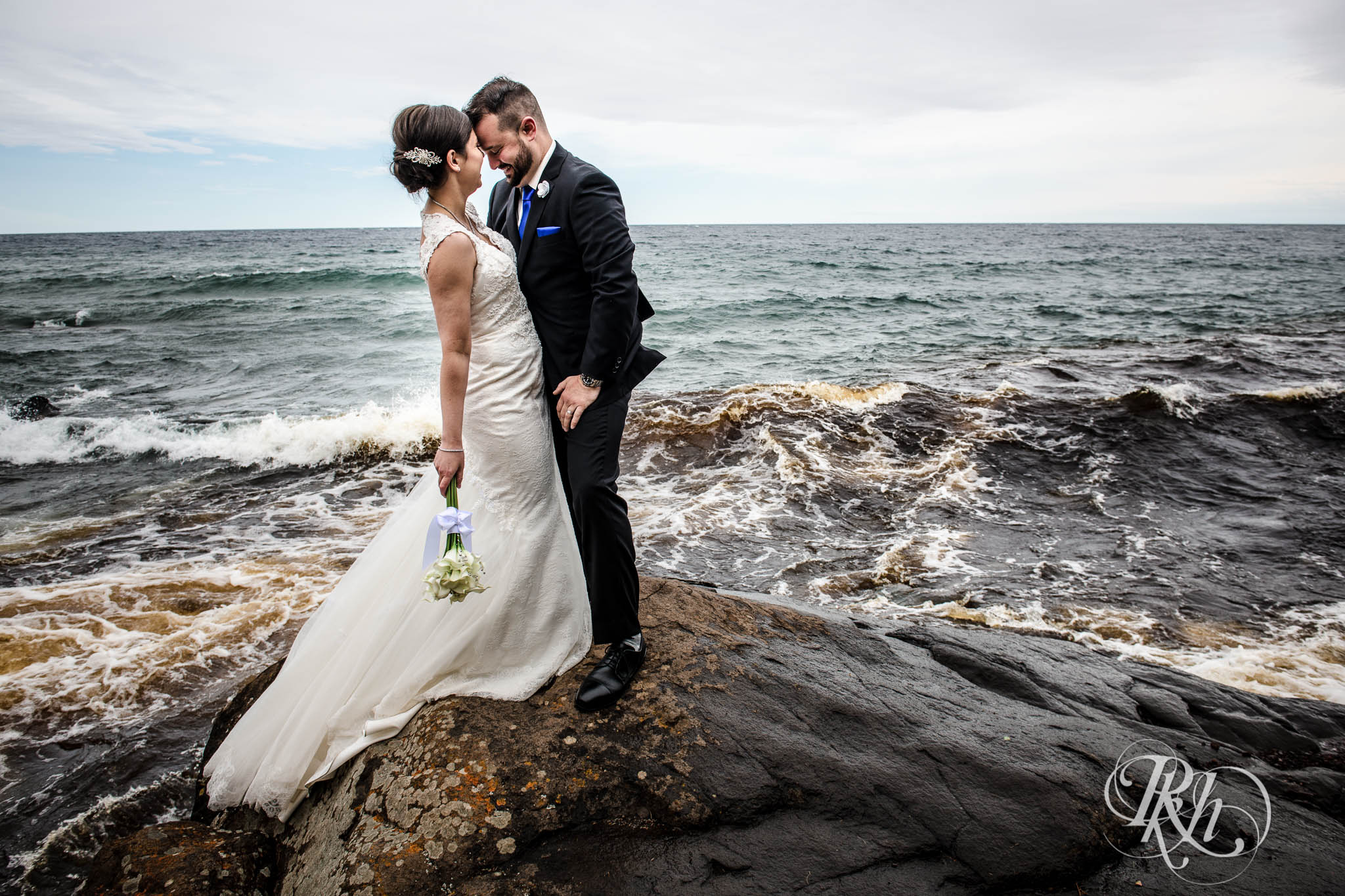 Bride and groom kiss in front of Lake Superior in North Shore in Minnesota.