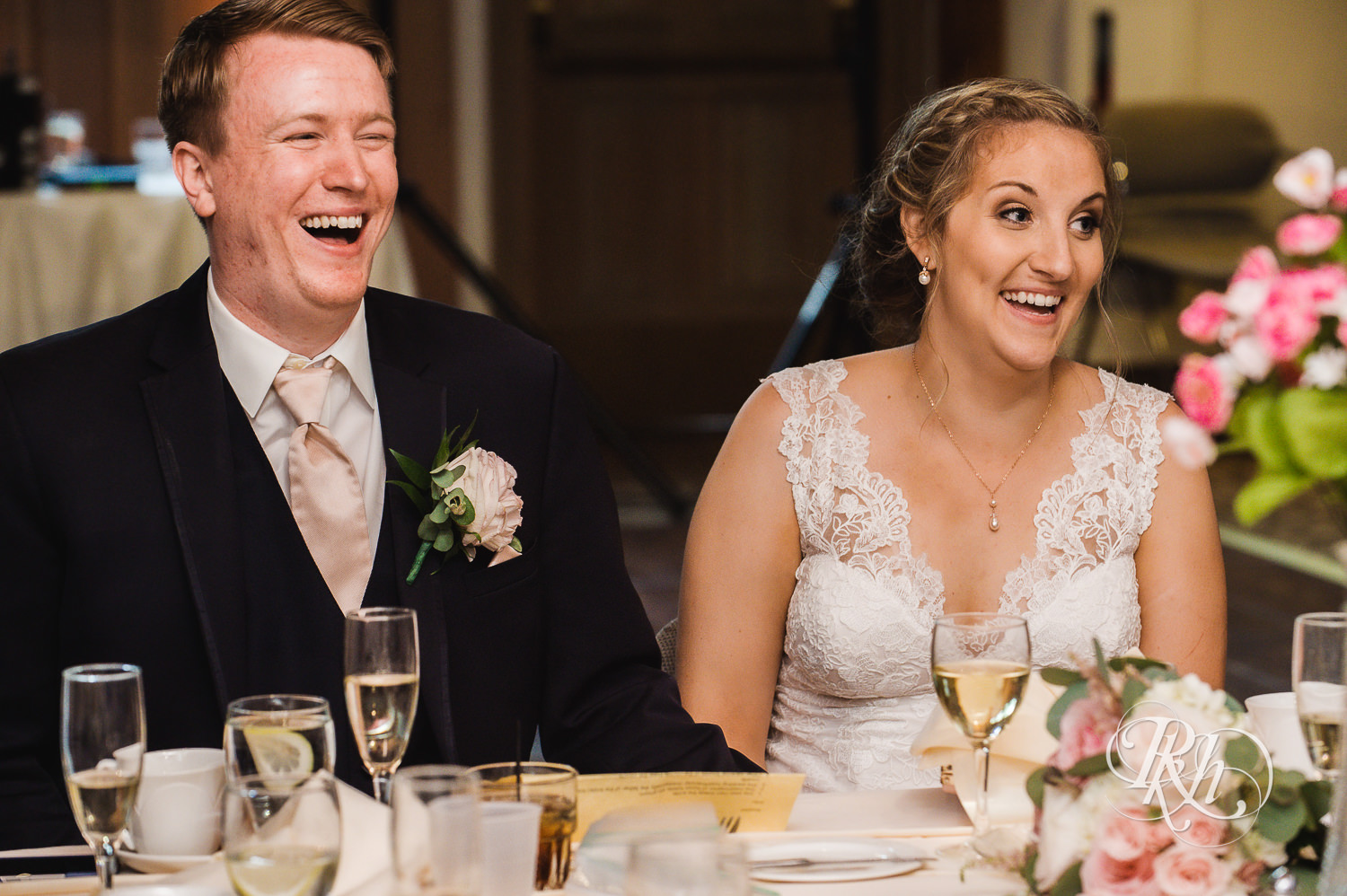 Bride and groom laugh during speeches at wedding reception at Earle Brown Heritage Center in Brooklyn Center, Minnesota.