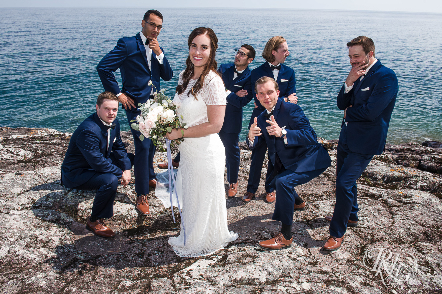 Wedding party smile on cliff in front of Lake Superior in Bluefin Bay wedding in Tofte, Minnesota.