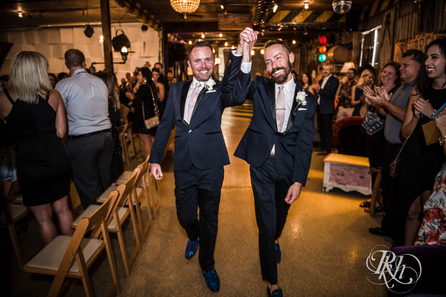 Grooms cheer after LGBTQ wedding ceremony at Warehouse Winery wedding in Saint Louis Park, Minnesota.