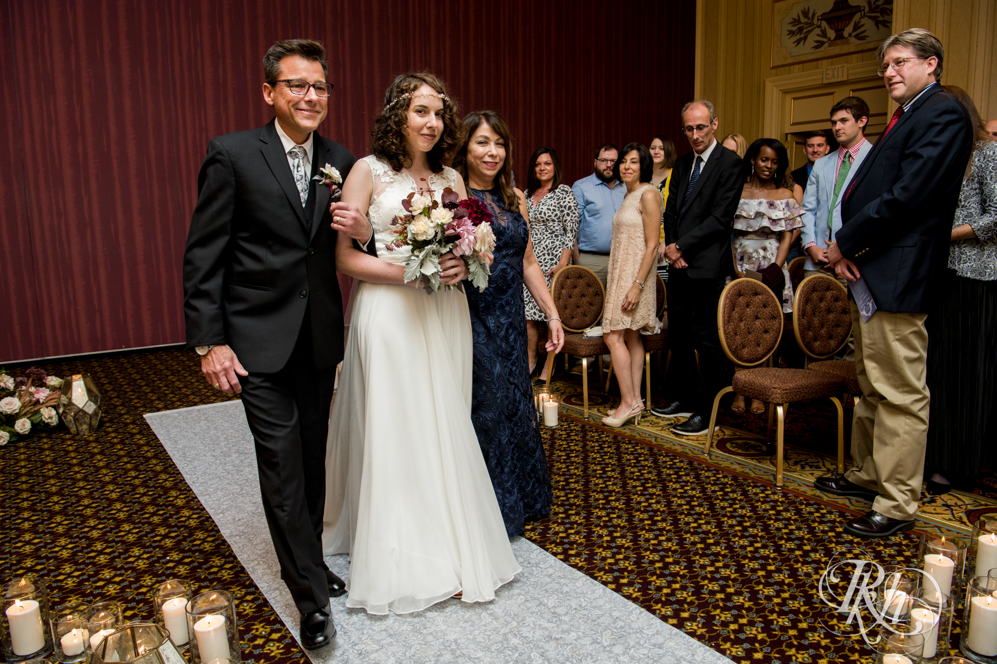 Bride walks down the aisle during wedding ceremony at the Saint Paul Hotel in Saint Paul, Minnesota.