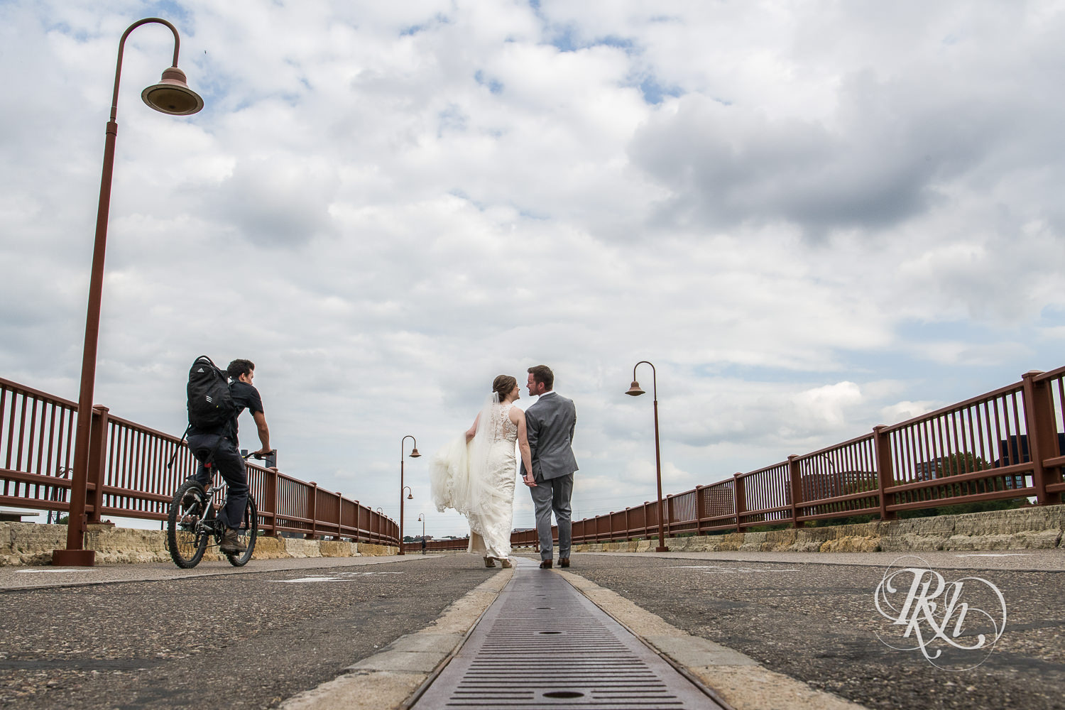 Bride and groom smile on the Stone Arch Bridge in Minneapolis, Minnesota.