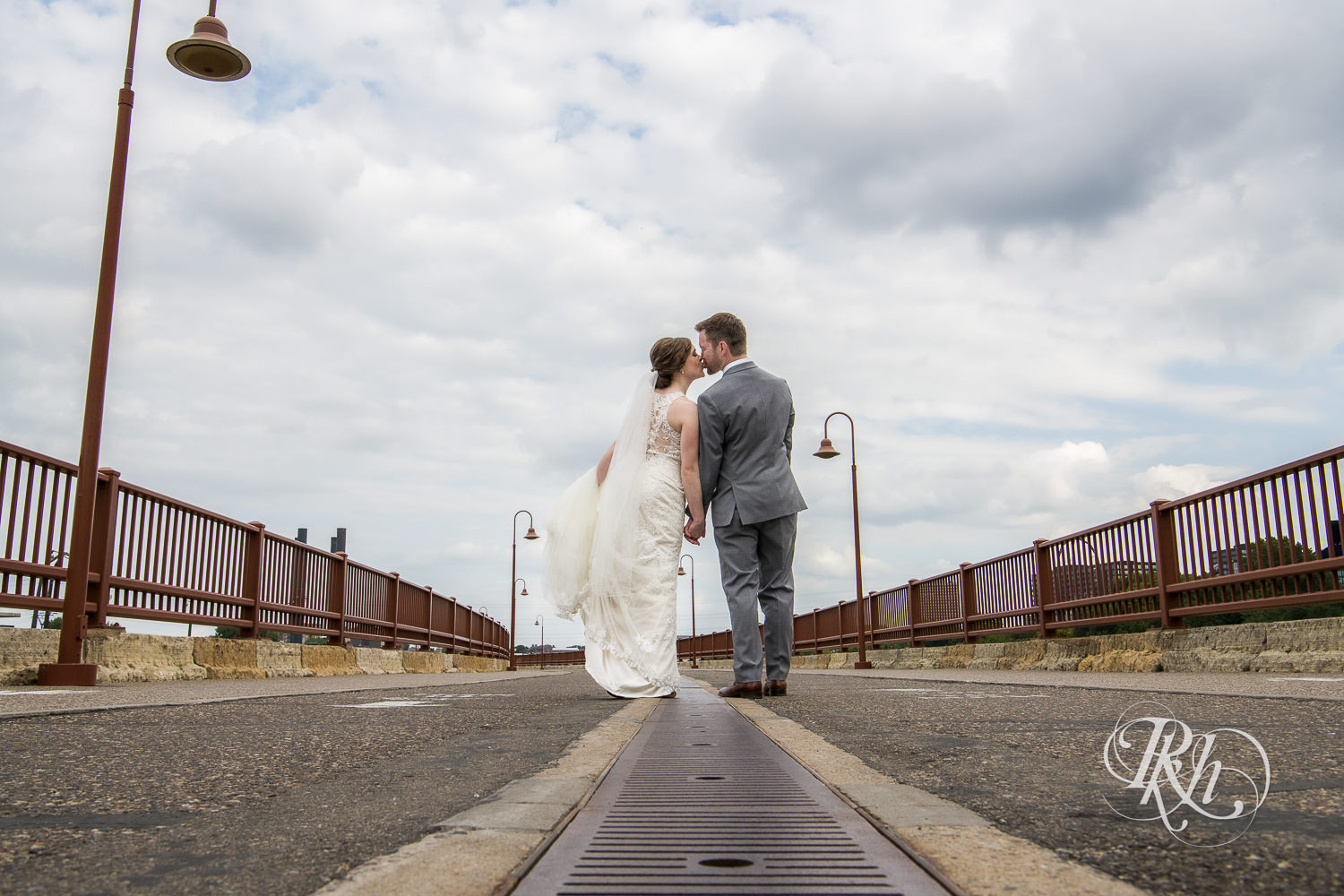 Bride and groom kiss on the Stone Arch Bridge in Minneapolis, Minnesota.