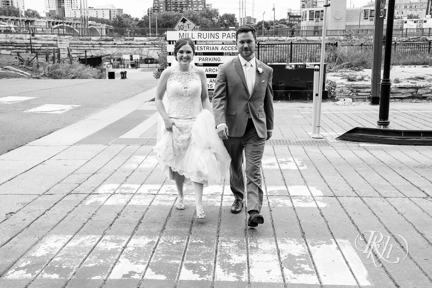 Bride and groom smile on the Stone Arch Bridge in Minneapolis, Minnesota.