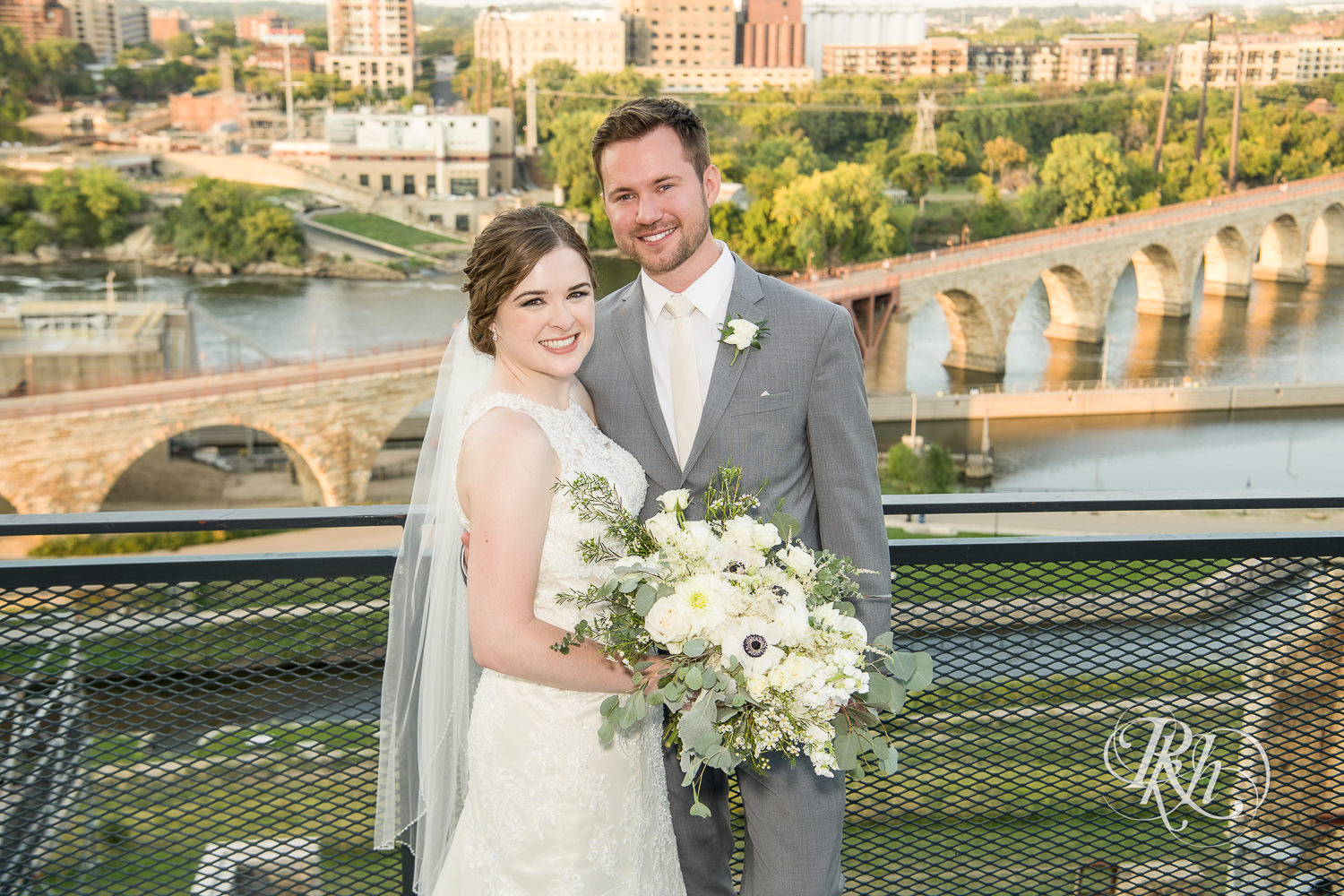 Bride and groom smile at sunset on top of Mill City Museum in Minneapolis, Minnesota.
