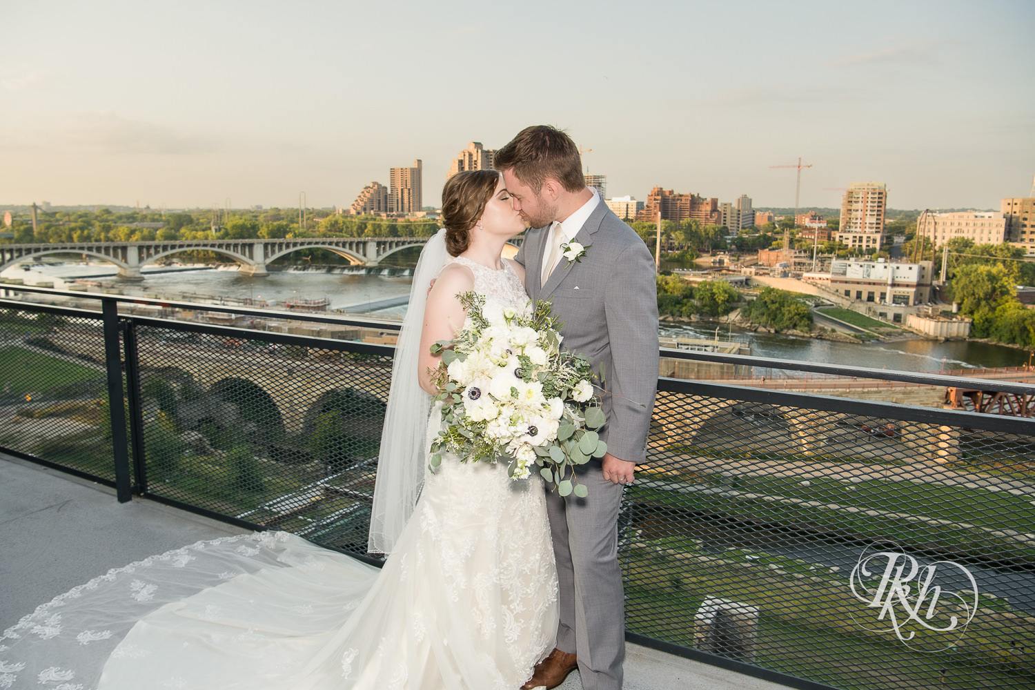 Bride and groom kiss at sunset on top of Mill City Museum in Minneapolis, Minnesota.