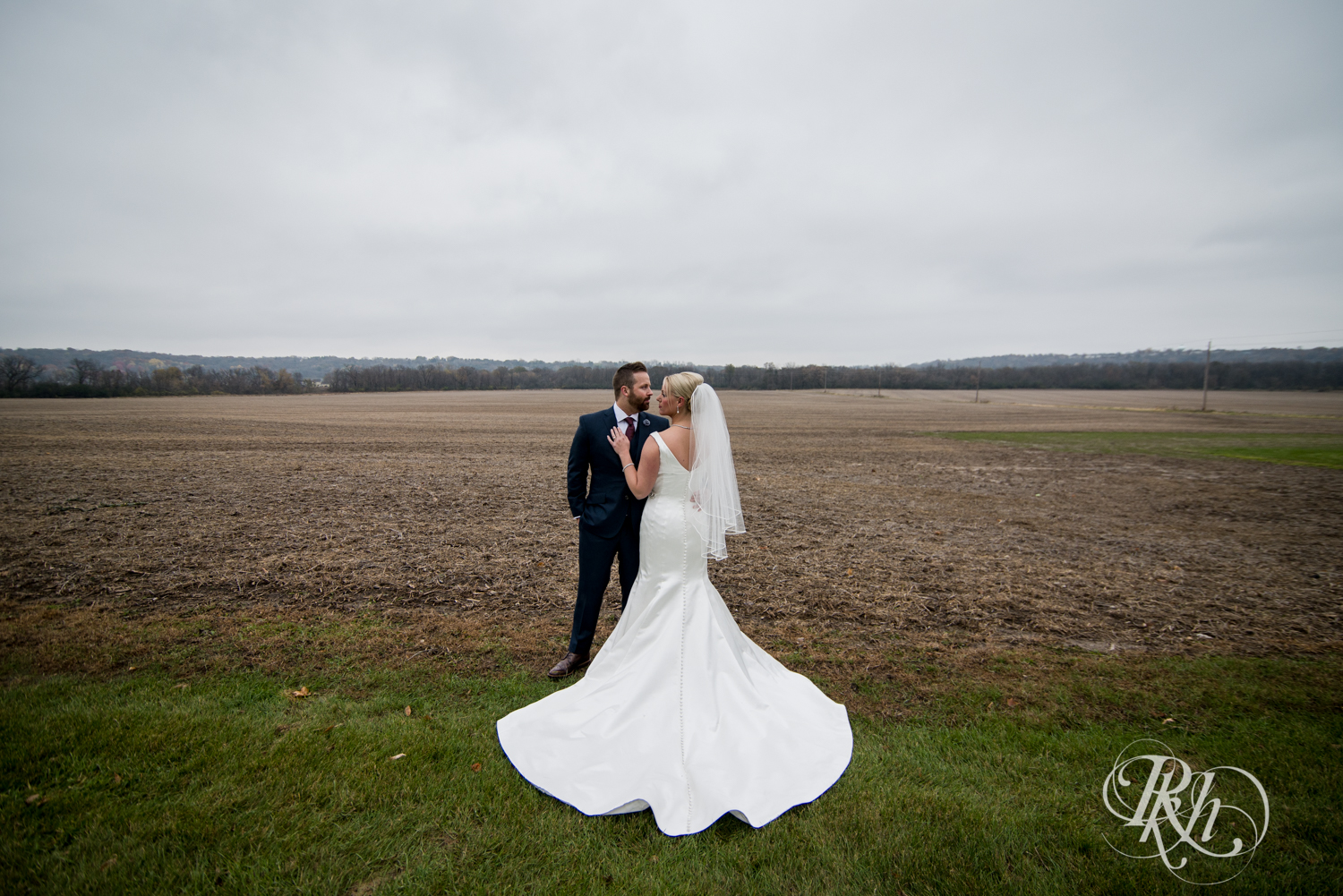 Bride and groom stand in fog at Mayowood Stone Barn in Rochester, Minnesota.