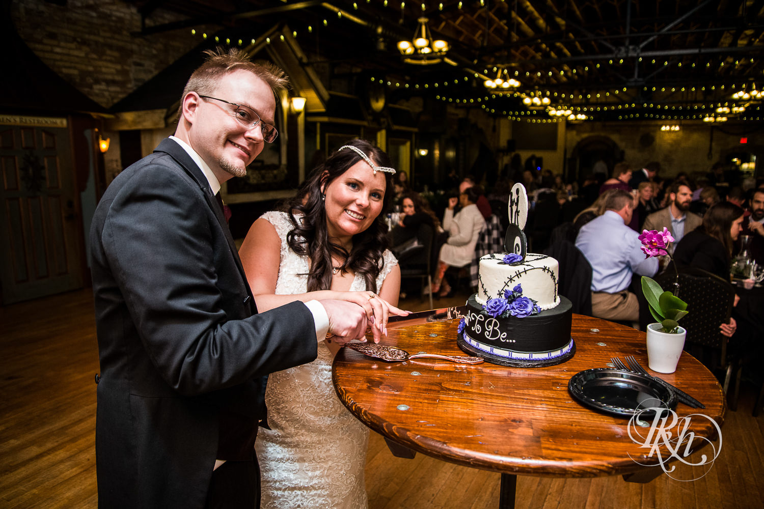 Bride and groom cut cake during indoor wedding reception at Kellerman's Event Center in White Bear Lake, Minnesota.