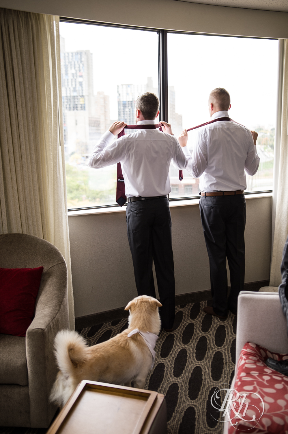 Dog watches grooms getting ready for wedding at Courtyard by Marriott Minneapolis in Minneapolis, Minnesota.