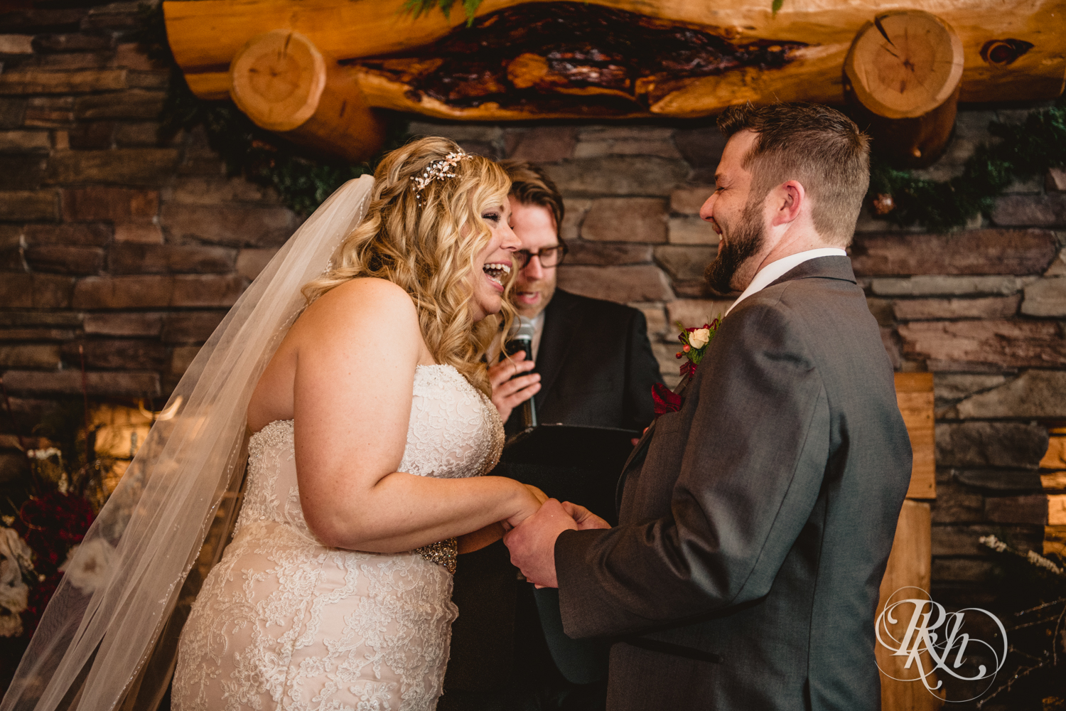 Bride and groom laugh during winter wedding ceremony at Whitefish Lodge in Crosslake, Minnesota.