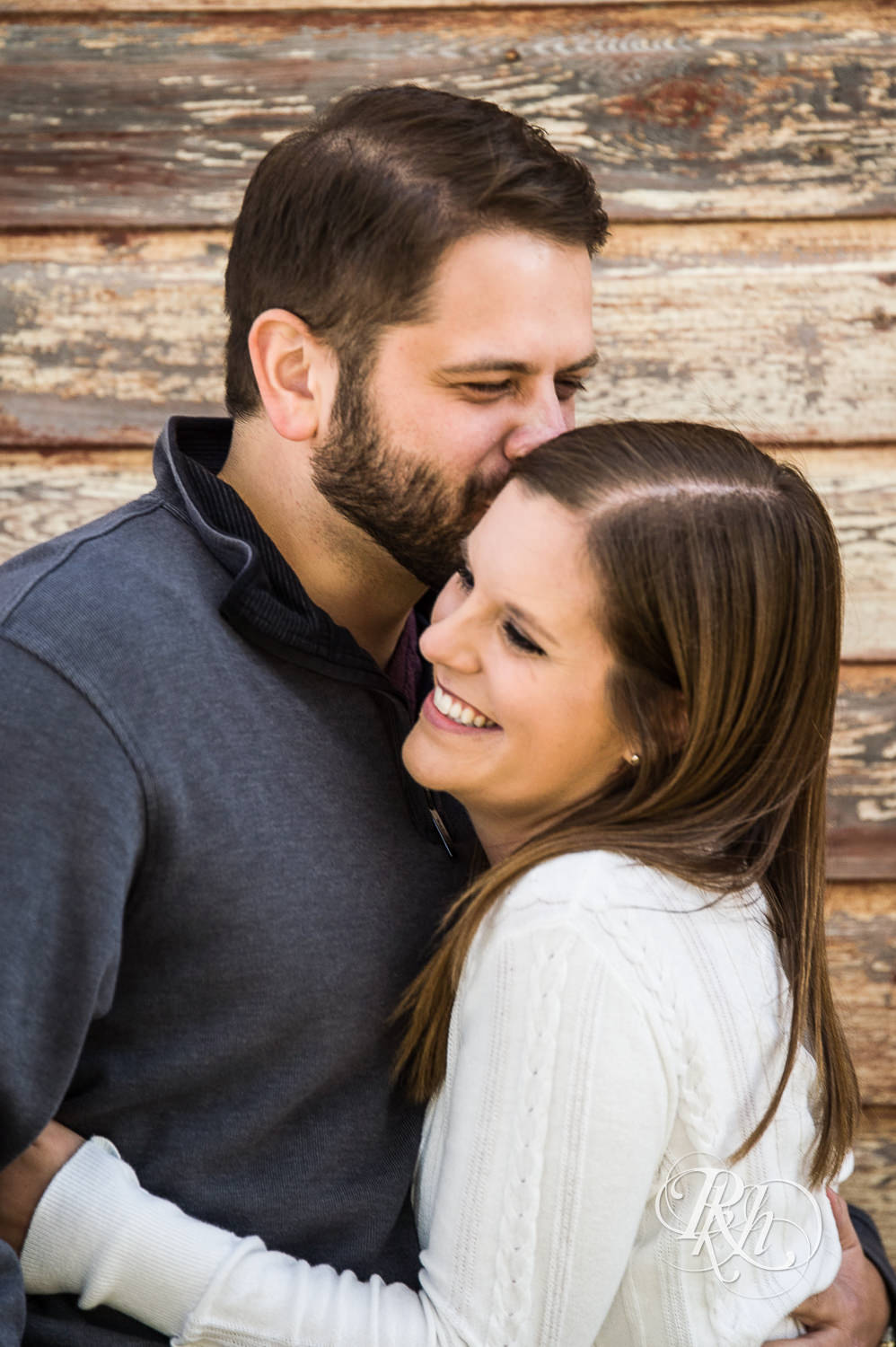 Man and woman kiss during engagement photography session at home in Annandale, Minnesota.