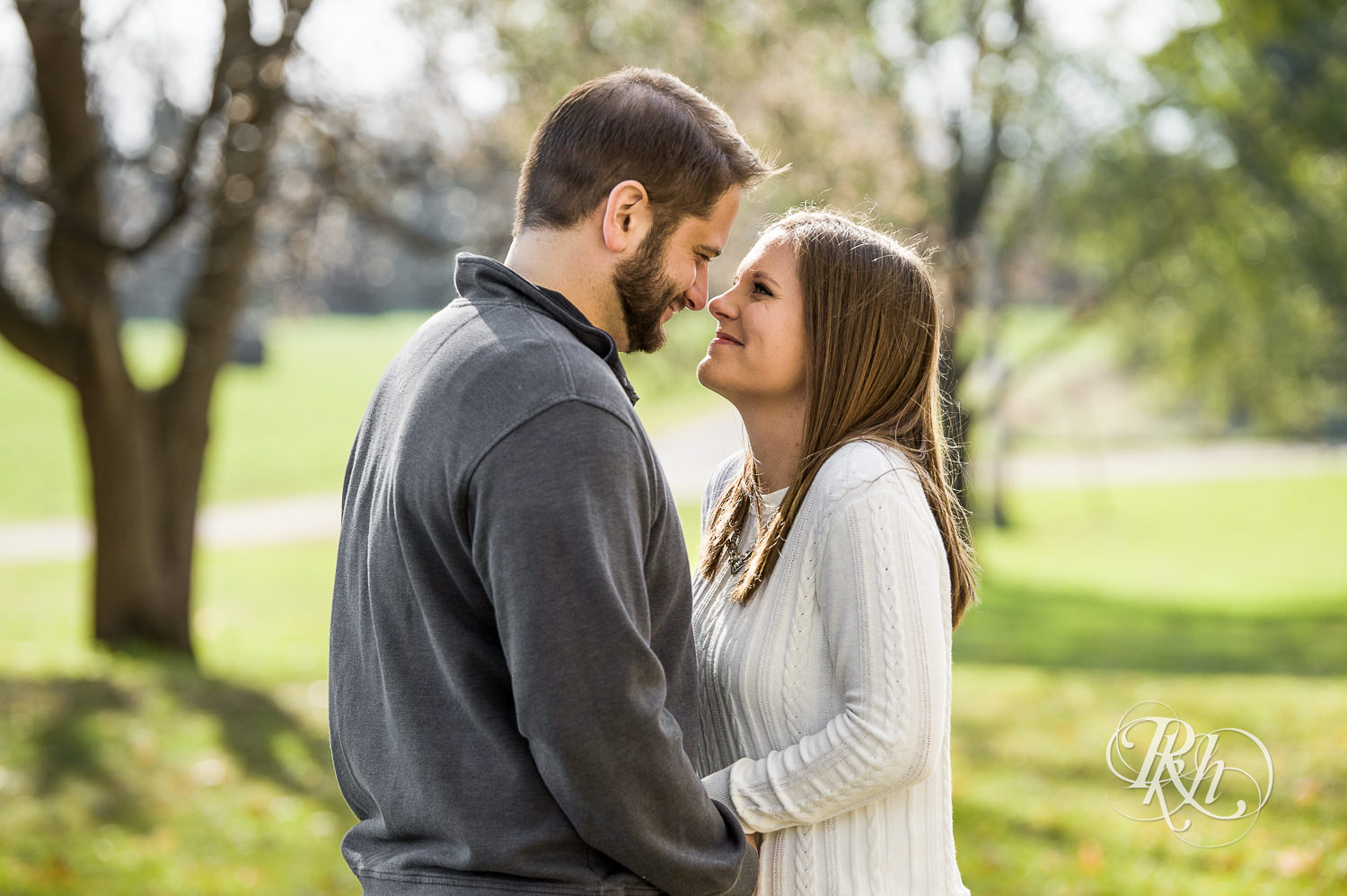 Man and woman smile during engagement photography session at home in Annandale, Minnesota.