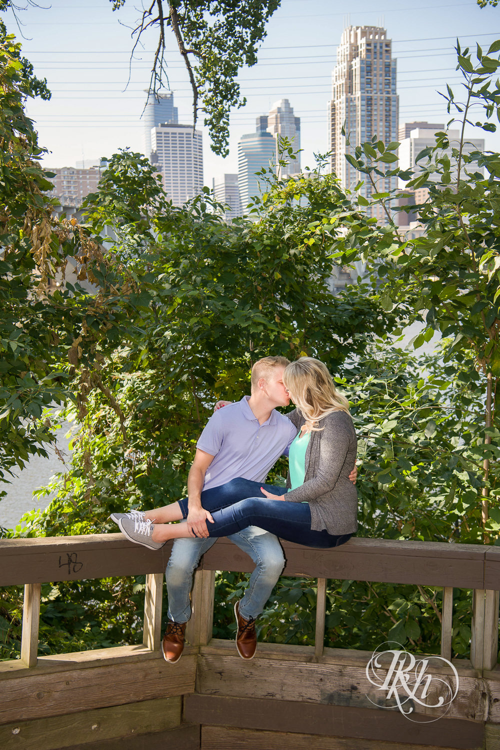 Man and woman smiling during Minneapolis summer engagement photos in Saint Anthony Main. 