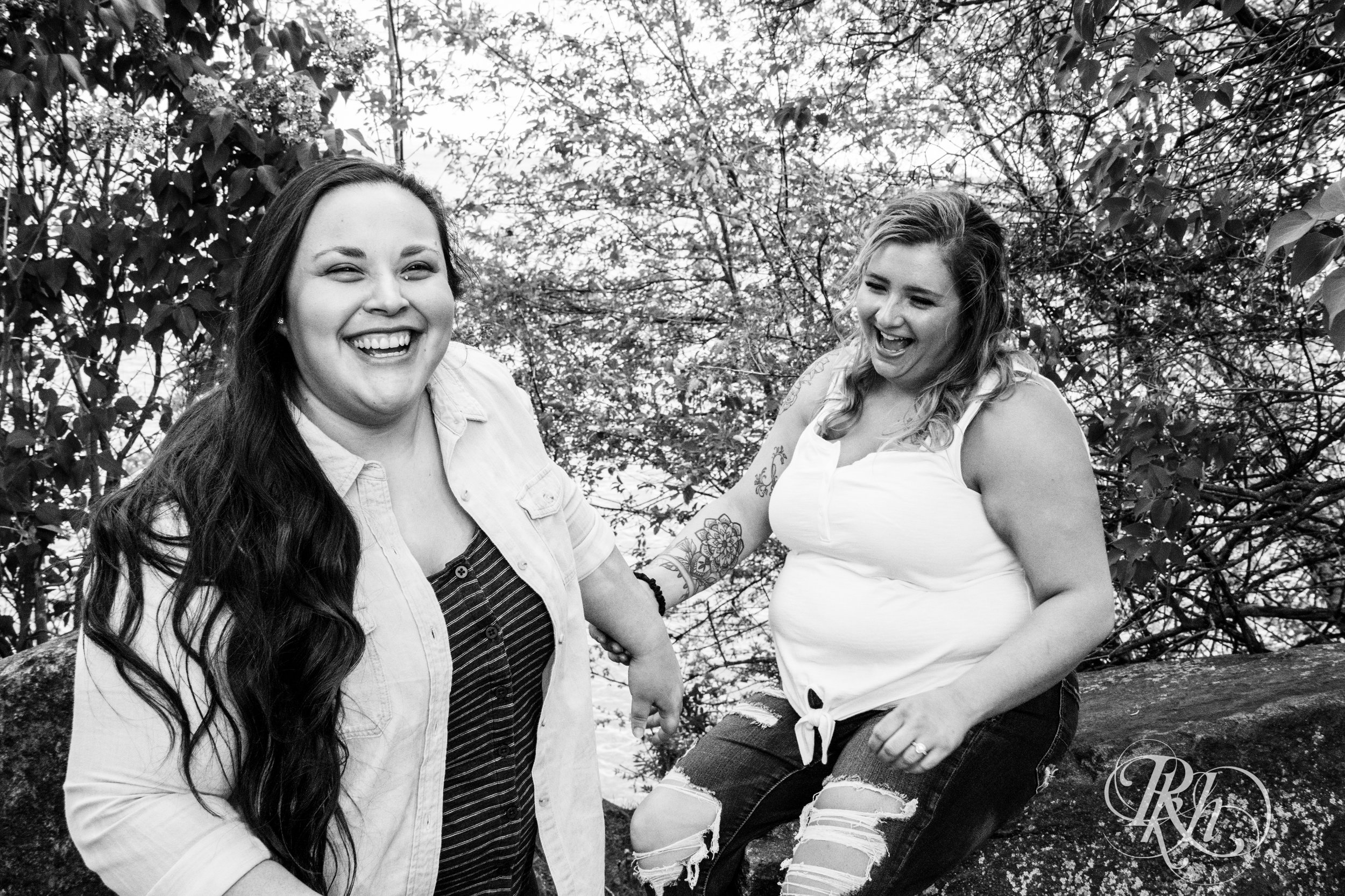 Lesbian couple laughs during engagement session in Duluth, Minnesota.