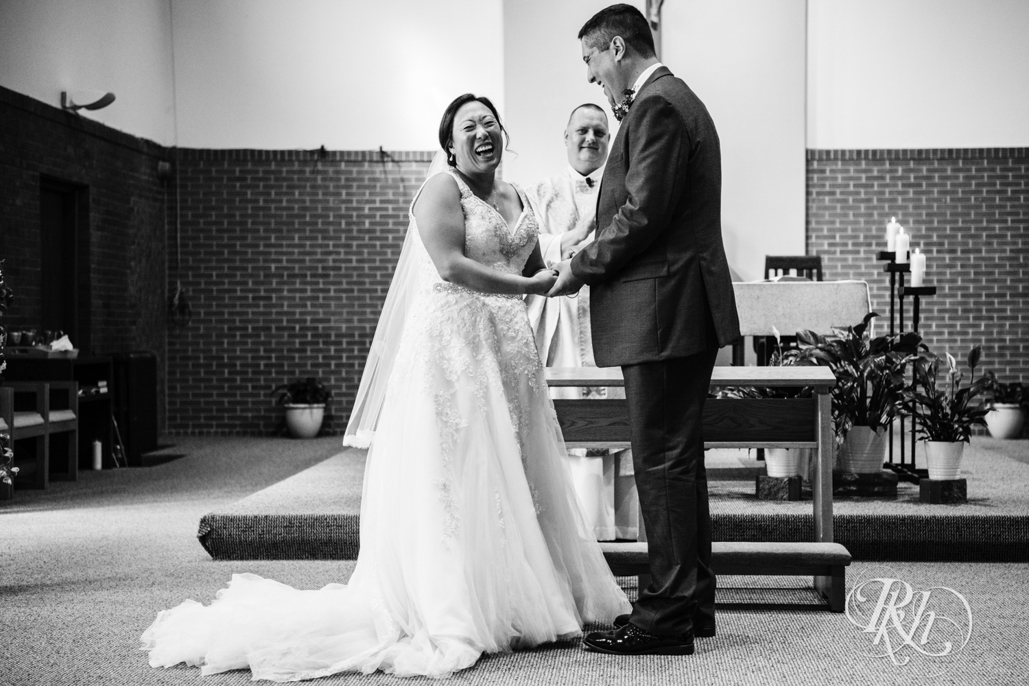Bride and groom laugh during church wedding ceremony in Minneapolis, Minnesota.