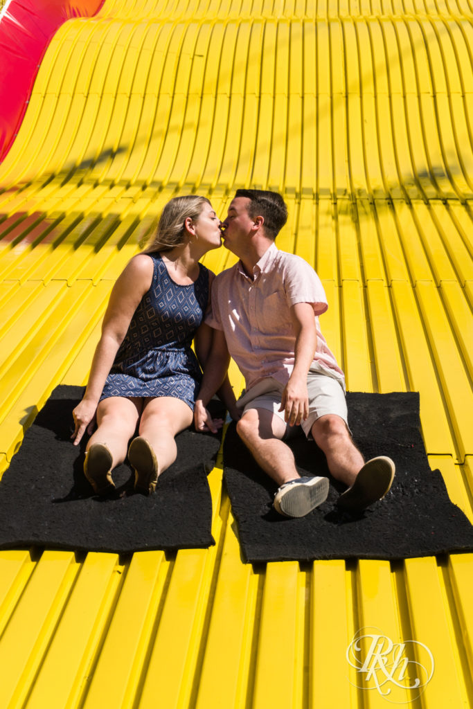 Man and woman in blue dress kissing while riding down the giant slide at the Minnesota State Fair.