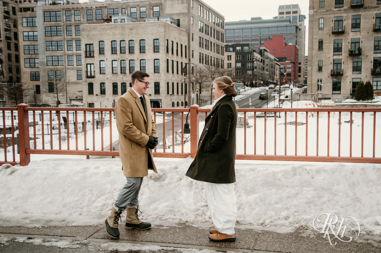 Bride and groom share first look on snow covered Stone Arch Bridge in Minneapolis, Minnesota.
