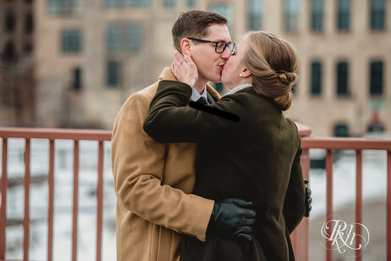 Bride and groom share first look on snow covered Stone Arch Bridge in Minneapolis, Minnesota.