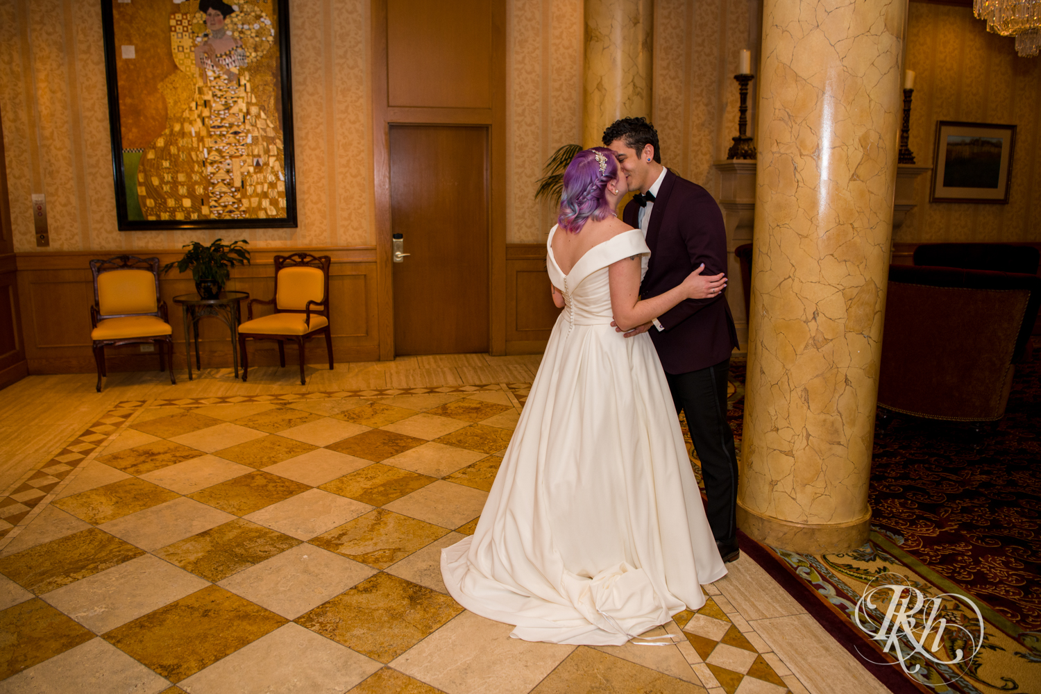 Bride with rainbow hair and groom in maroon suit share first look at the Saint Paul Hotel in Saint Paul, Minnesota.