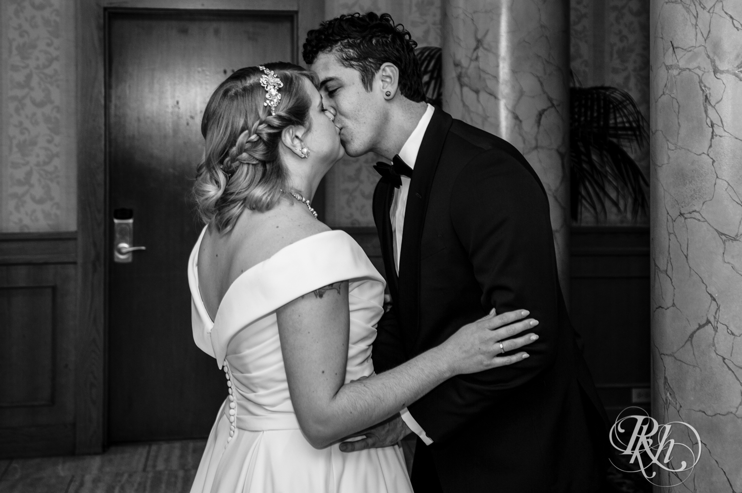 Bride with rainbow hair and groom in maroon suit kiss at the Saint Paul Hotel in Saint Paul, Minnesota.