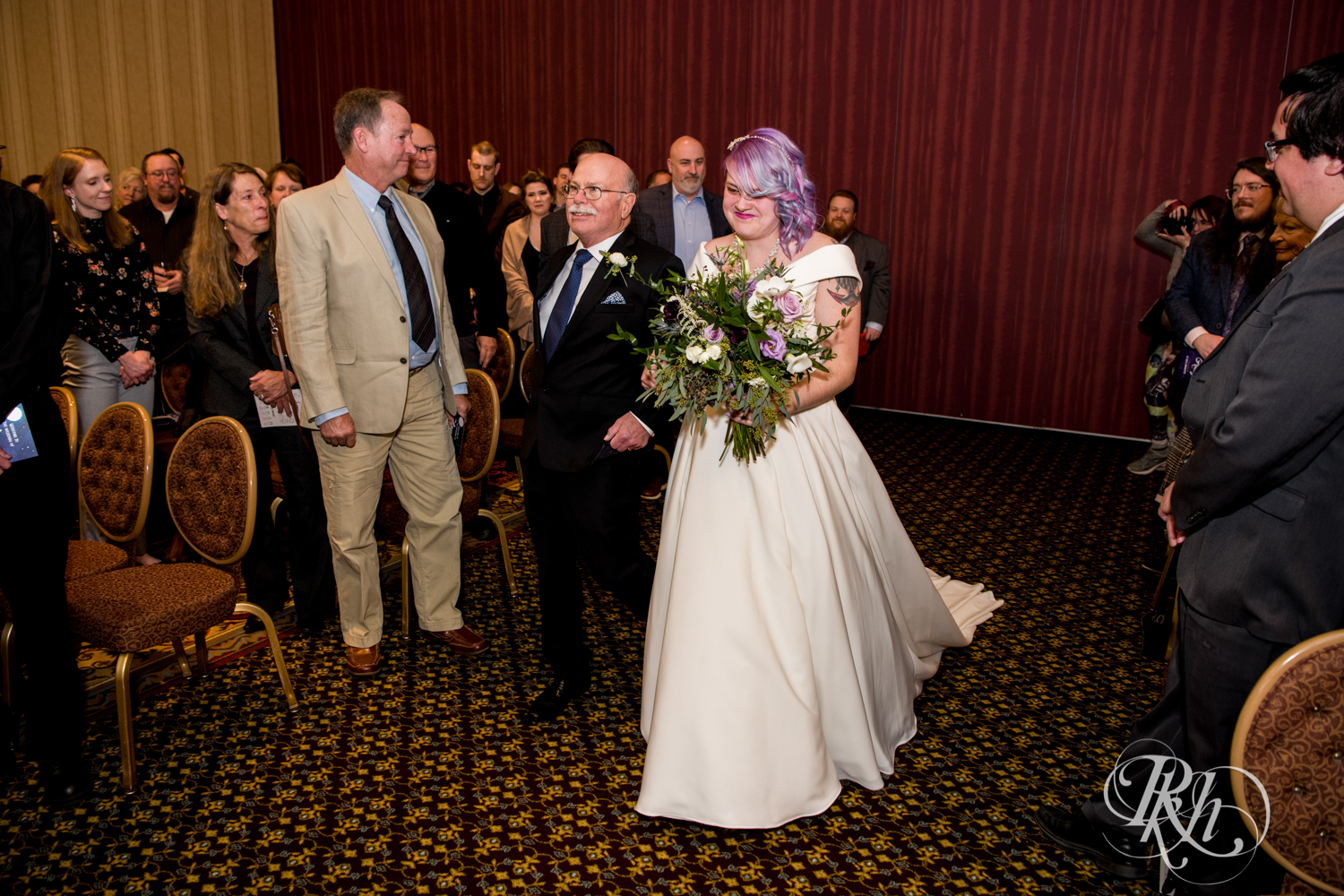 Bride with rainbow hair walking down the aisle at wedding ceremony at the Saint Paul Hotel in Saint Paul, Minnesota.
