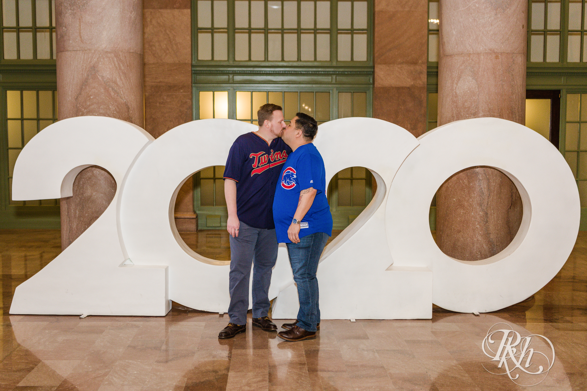 Two gay men in baseball jerseys kiss in Union Depot in Saint Paul, Minnesota.