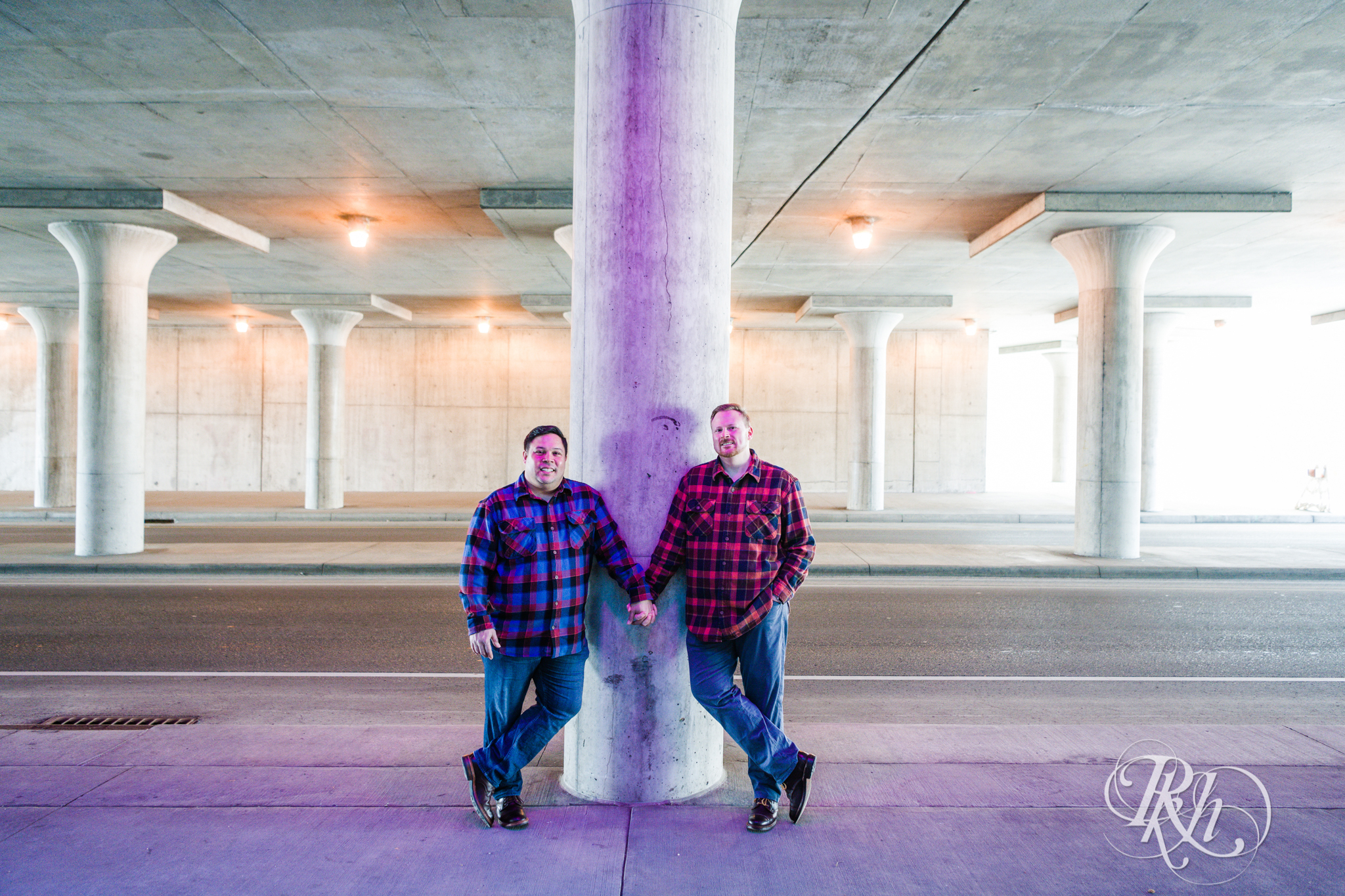 Two gay men in flannels hold hands near Union Depot in Saint Paul, Minnesota.