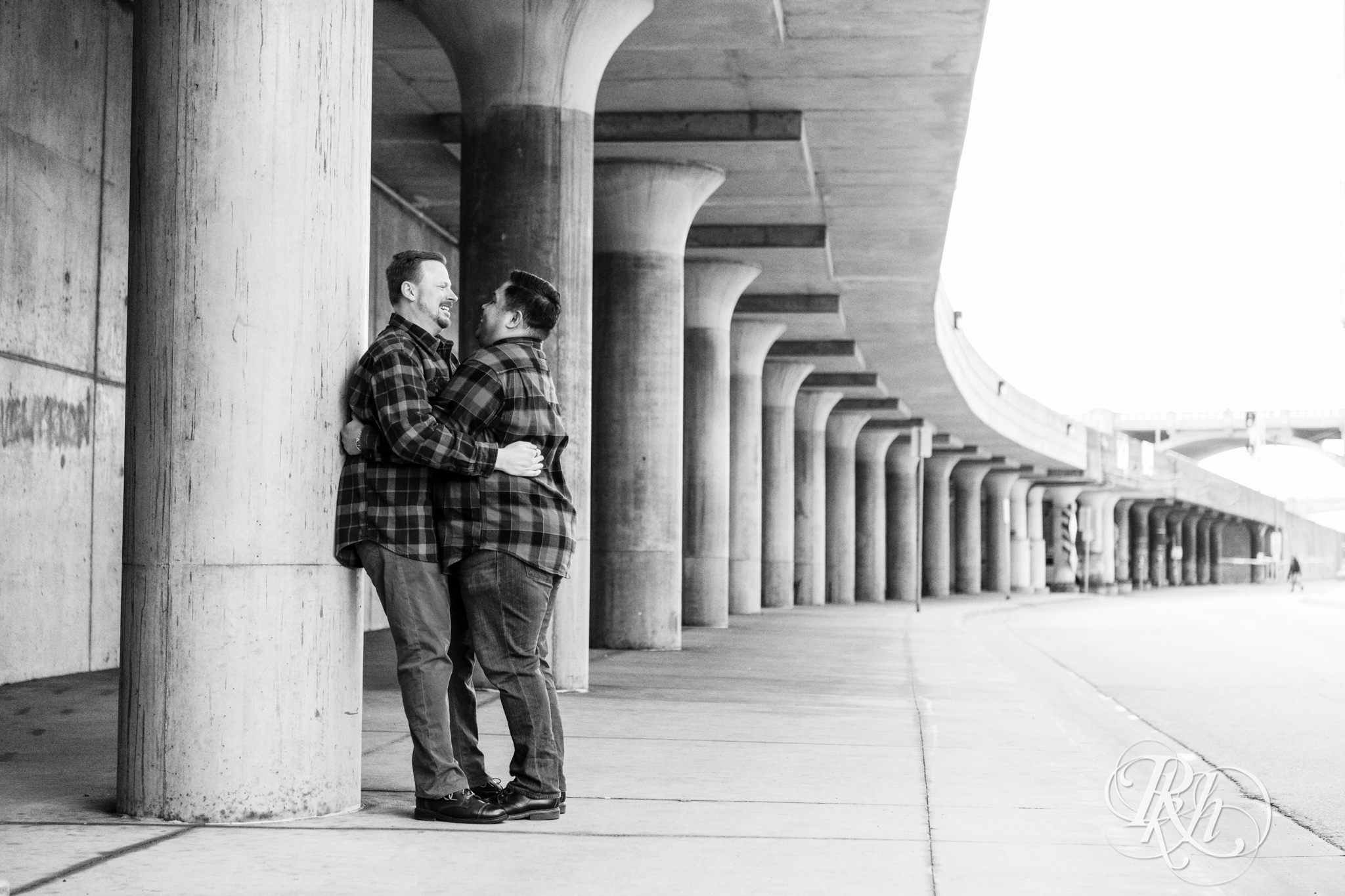Two gay men in flannels smile near Union Depot in Saint Paul, Minnesota.